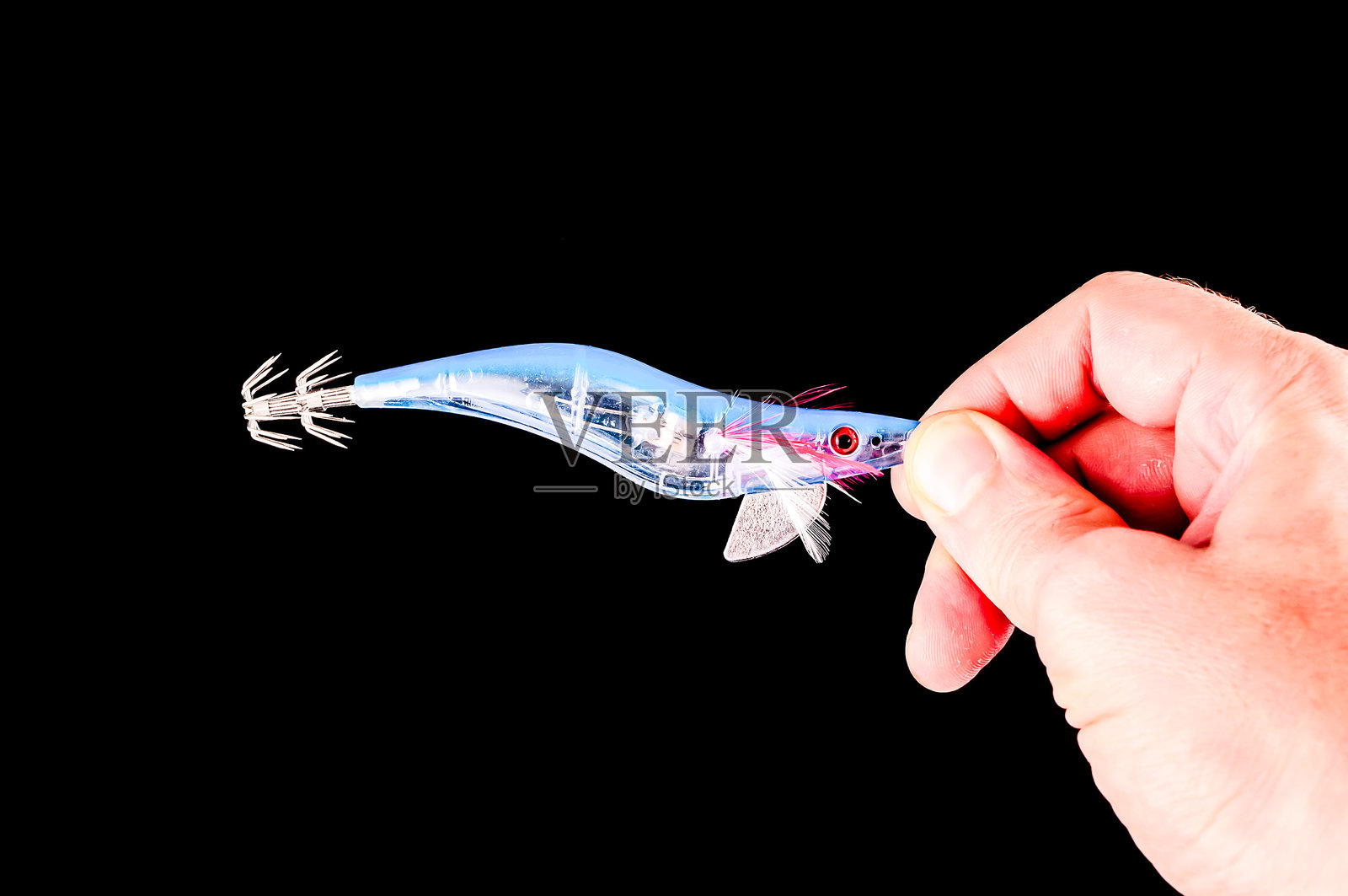 一只手握着一个蓝色物体,物体的尖端是红色的照片摄影图片