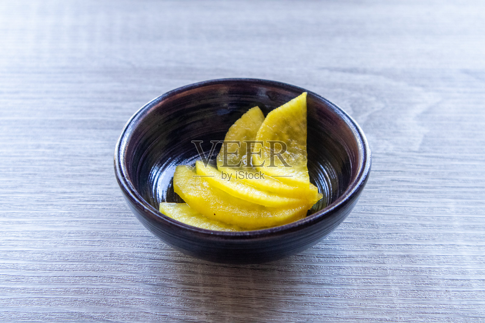 黑色盘子里的丹姆吉(韩国腌萝卜)放在木桌上照片摄影图片