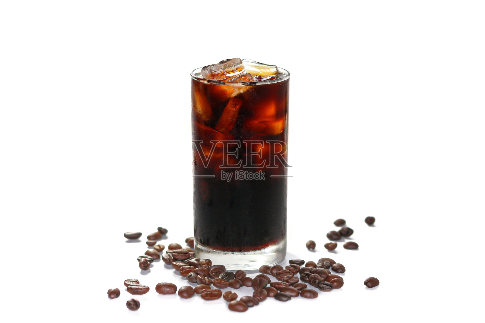美式冰咖啡在白色背景上盛放,咖啡豆散落在玻璃周围,突出孤立的概念。照片摄影图片