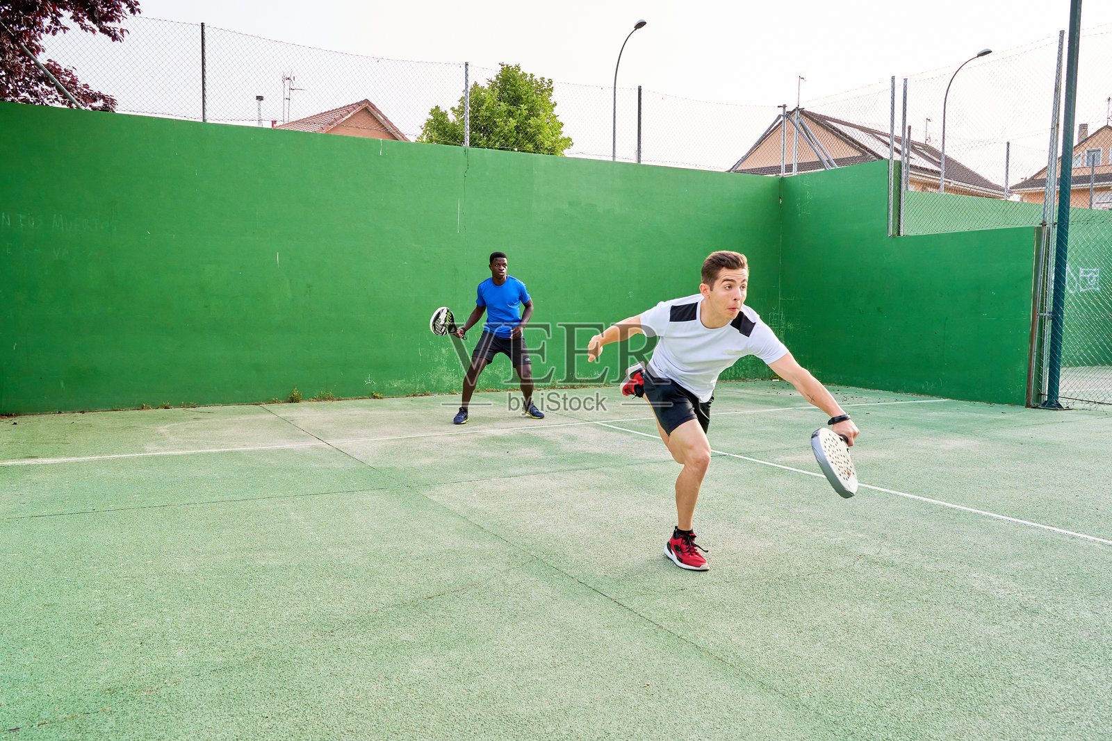 两个年轻朋友在球场上打乒乓球。运动概念。留白空间照片摄影图片