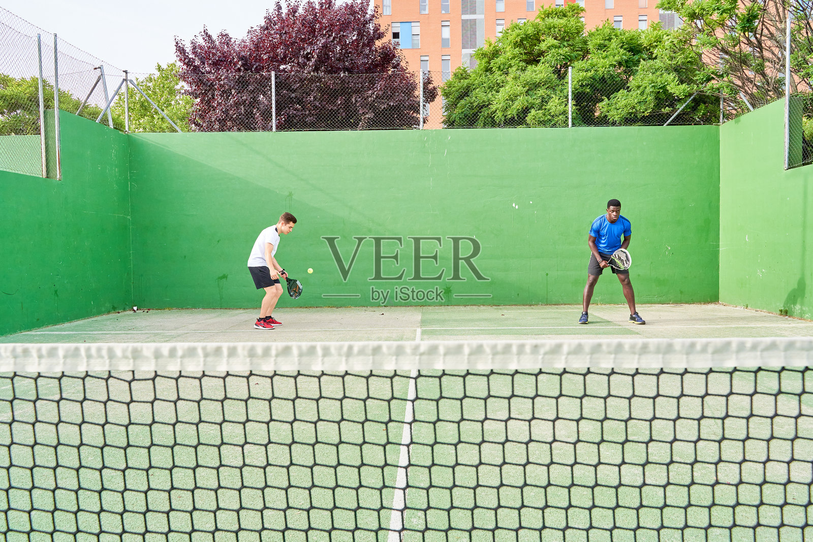 两个年轻朋友在球场上打乒乓球。运动概念。留白空间照片摄影图片