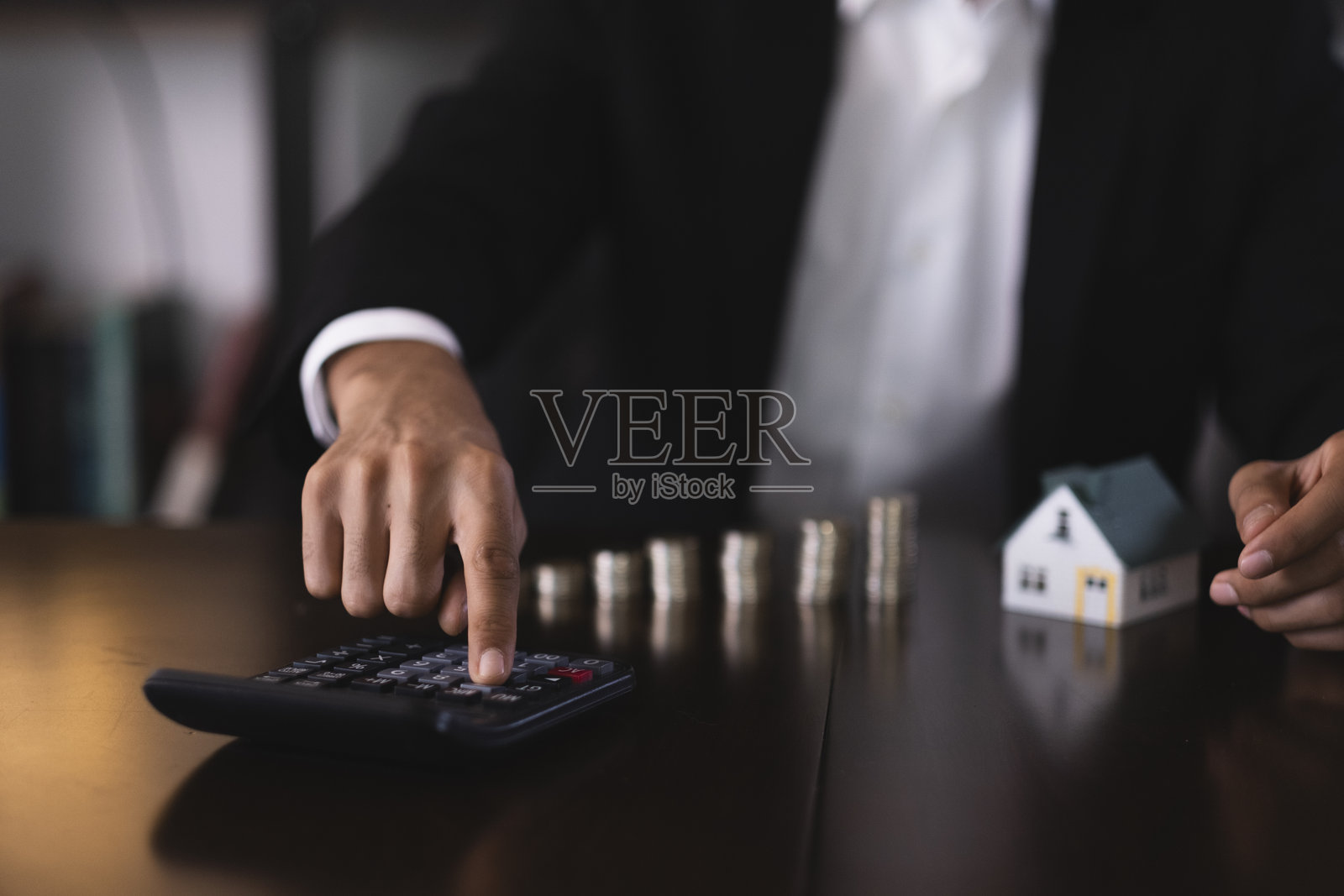 商人使用计算器计算房屋开支照片摄影图片