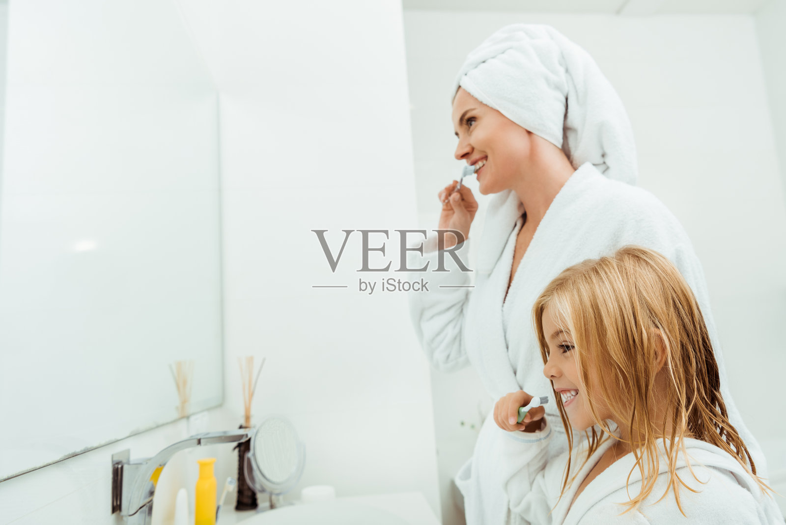 母女在温馨的浴室里一起分享睡前例行活动。照片摄影图片