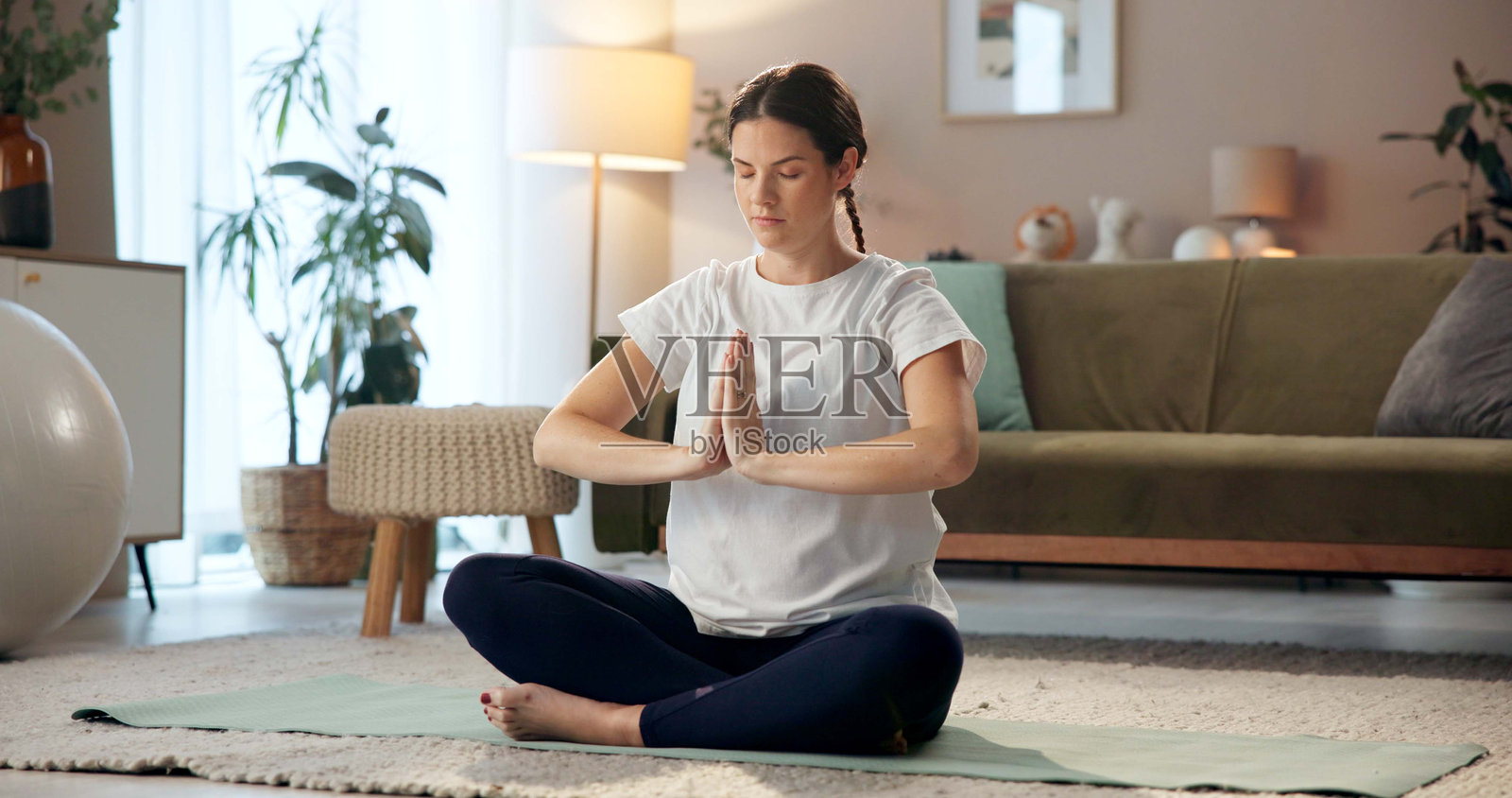 孕妇在家中休息室的地板上冥想,瑜伽垫上追求平和、平衡与禅意,促进健康。母亲与怀孕的正念,呼吸或合十礼在家中的客厅。照片摄影图片