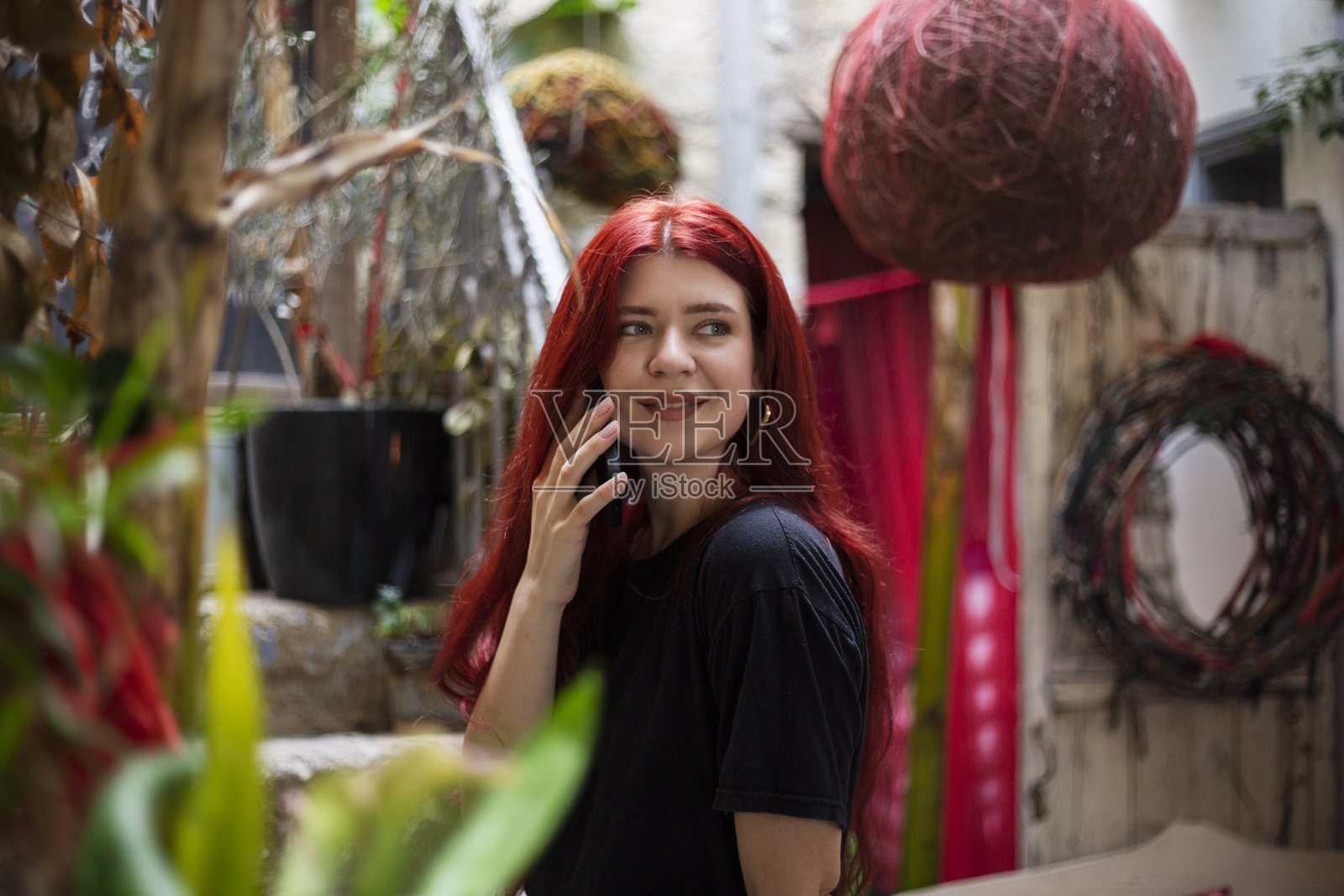 年轻美丽的红发女性在石阶上使用智能手机照片摄影图片