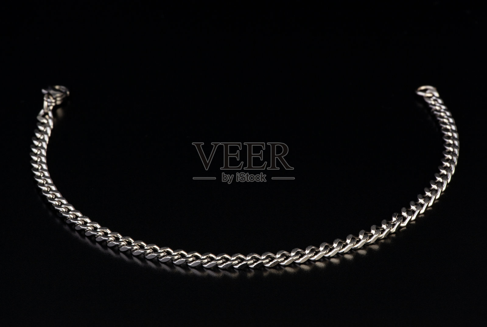 黑色背景上的银链项链照片摄影图片