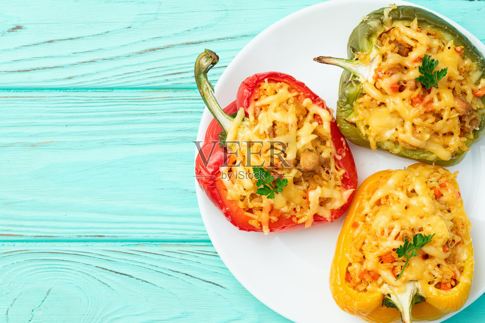 米饭、胡萝卜和肉馅的烤填充椒(红椒)。顶部视角,背景为乡村风格。照片摄影图片