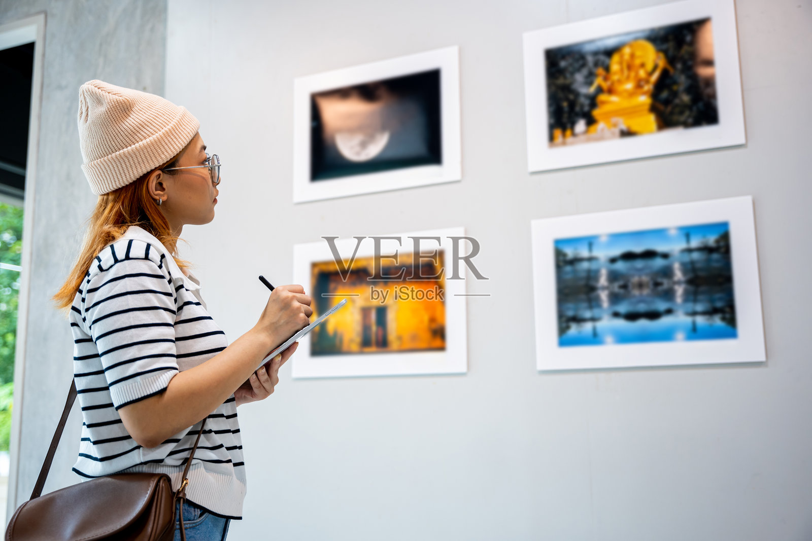 年轻人在展览艺术作品时,使用相框写数字书籍照片摄影图片