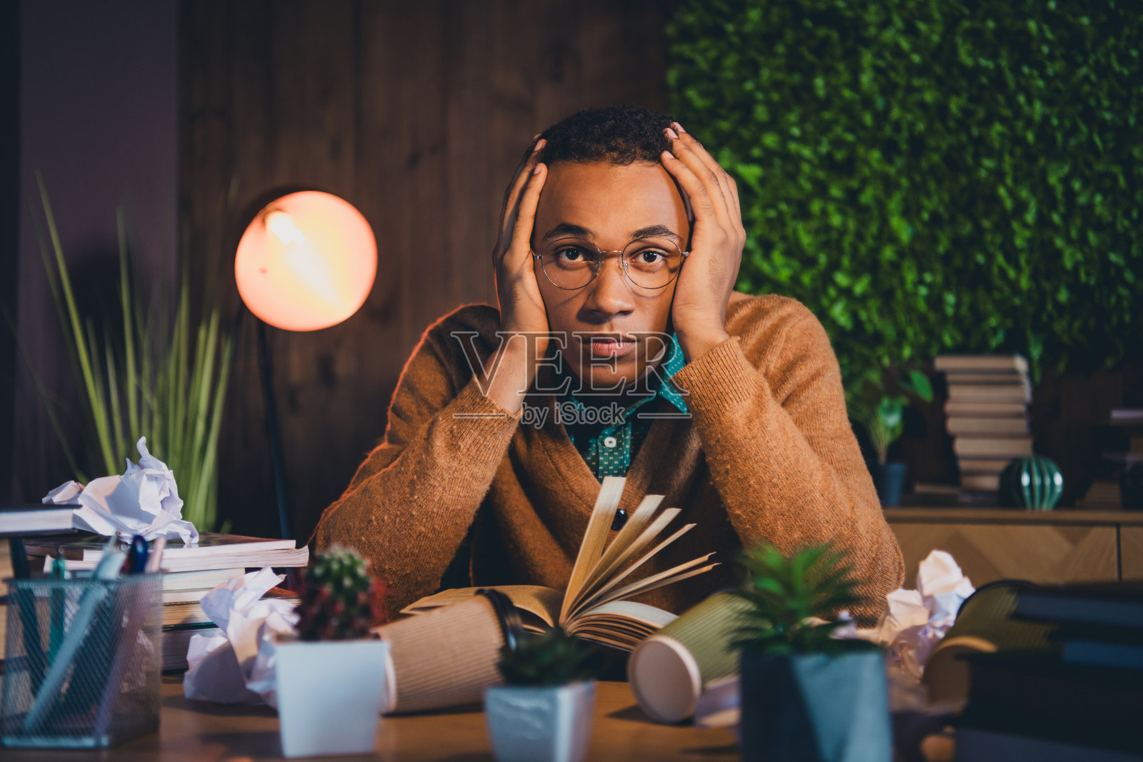 年轻学生在舒适的室内环境中学习时感到压力。照片摄影图片