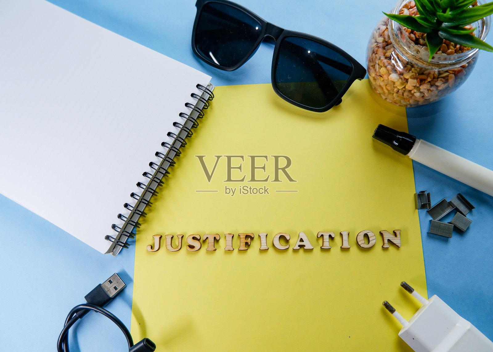 “JUSTIFICATION”字样的木制字母概念,孤立在黄色和蓝色背景上。照片摄影图片