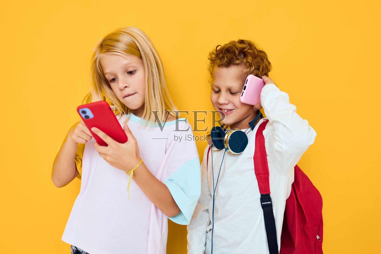 他/她的肖像,拿着手机做鬼脸,背景孤立,充满乐趣。照片摄影图片