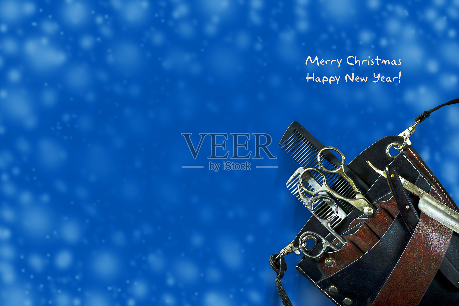 深蓝色背景上的美发工具。新年,圣诞卡片。祝理发师新年快乐和圣诞快乐。照片摄影图片