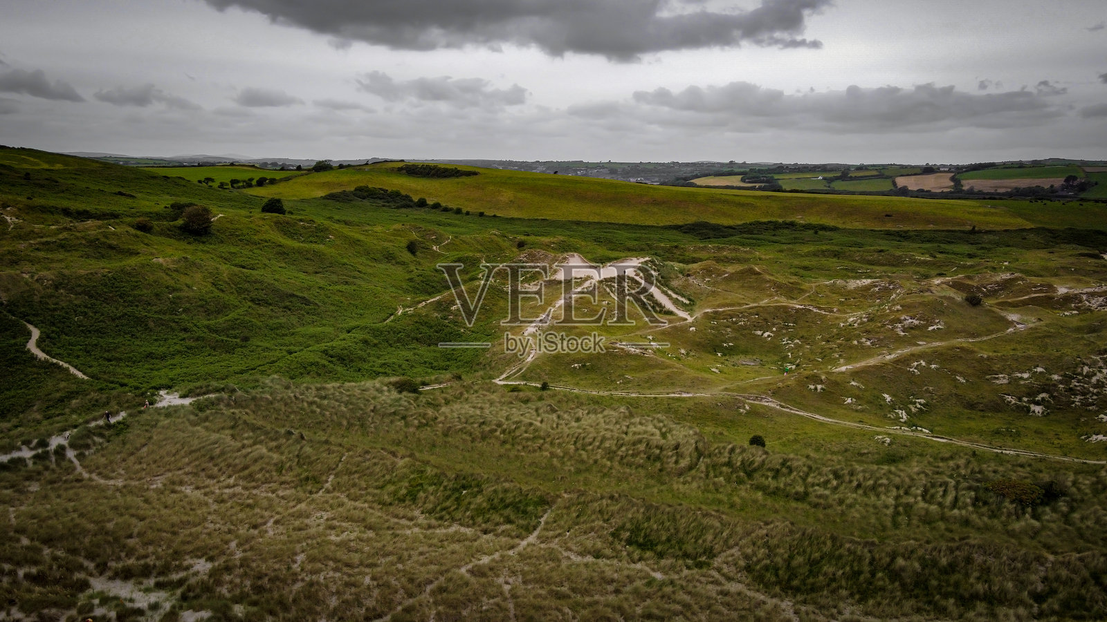 多云天空下的海岸沙丘与植被。爱尔兰风景。照片摄影图片