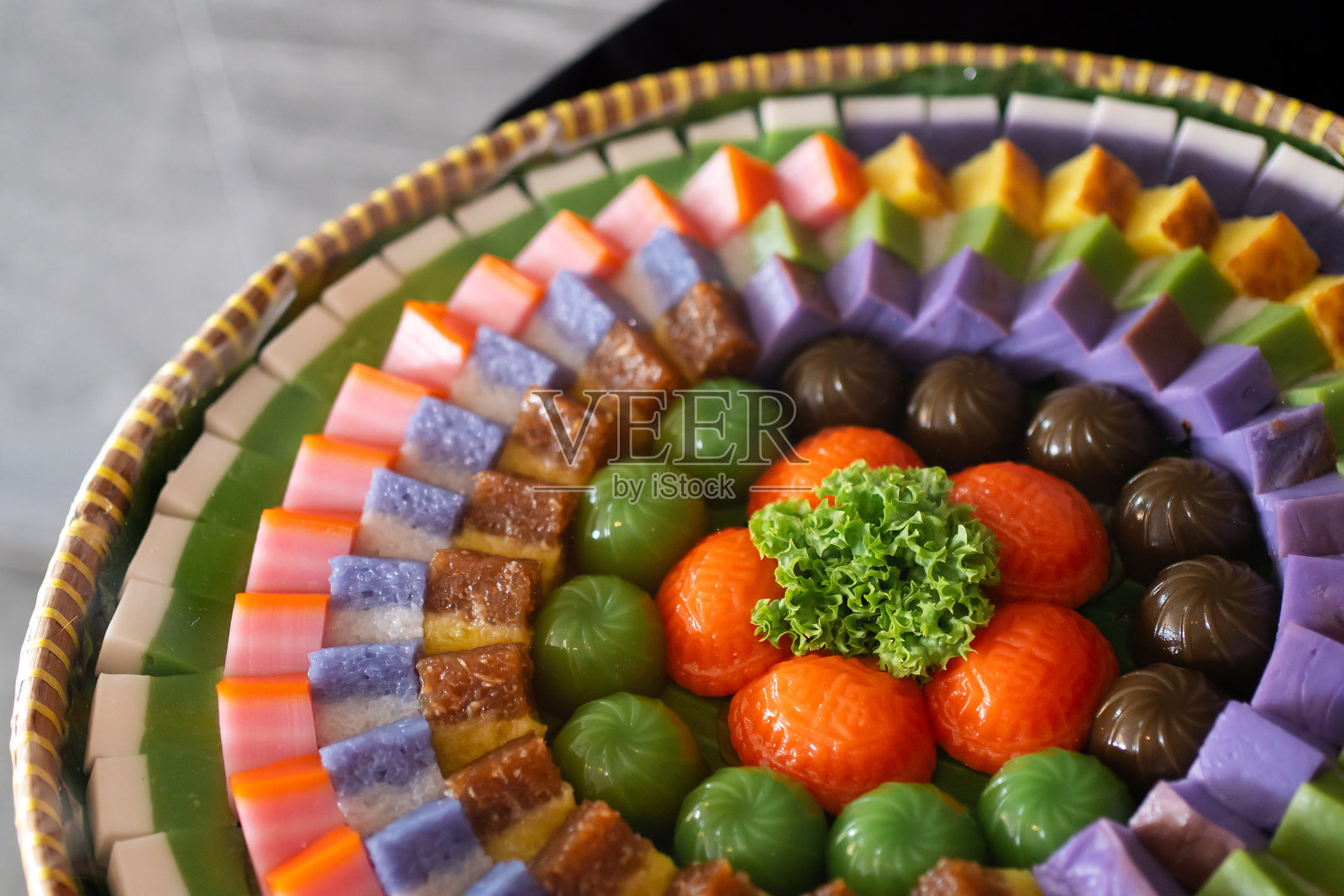 传统娘惹糕点放在藤编篮子托盘上。马来西亚美食,各种甜点。自助餐概念。照片摄影图片