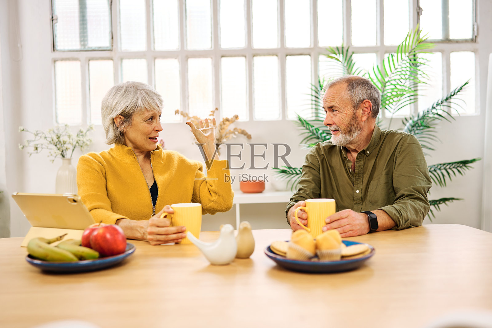 老年夫妇在家享用早餐并交谈照片摄影图片