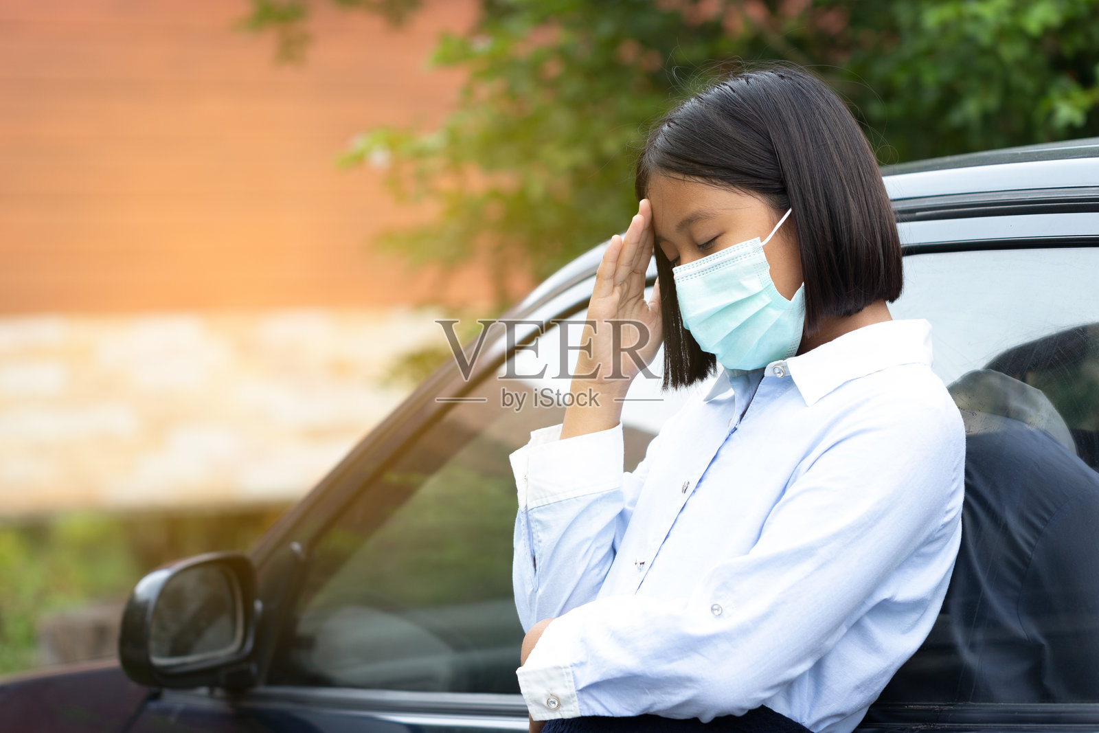 戴着口罩的女孩在车旁头痛照片摄影图片