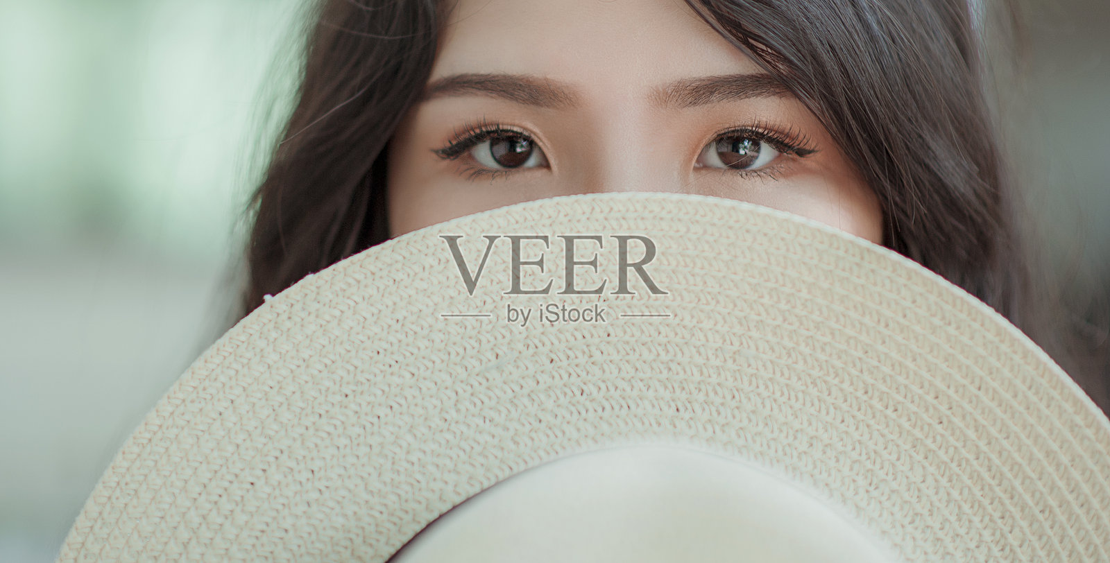 戴着太阳帽遮住脸的女性肖像照片摄影图片