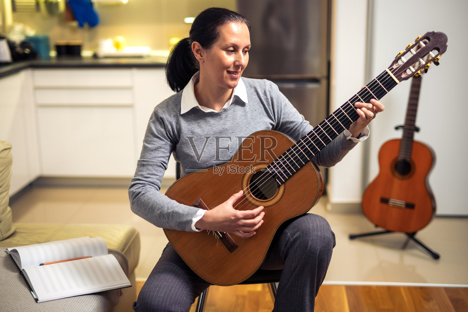 成熟的女性在家弹吉他照片摄影图片