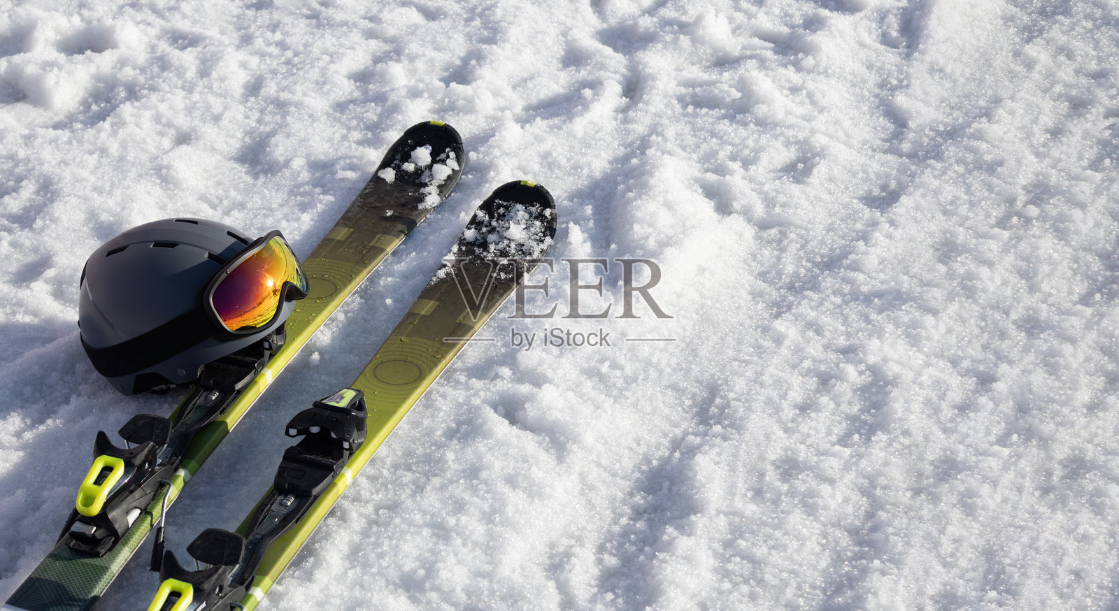 山地滑雪板、滑雪头盔配防晒面罩/滑雪护目镜,置于明亮的阿尔卑斯雪地上。冬季假期。极限运动。度假、旅行内容。留白空间。照片摄影图片
