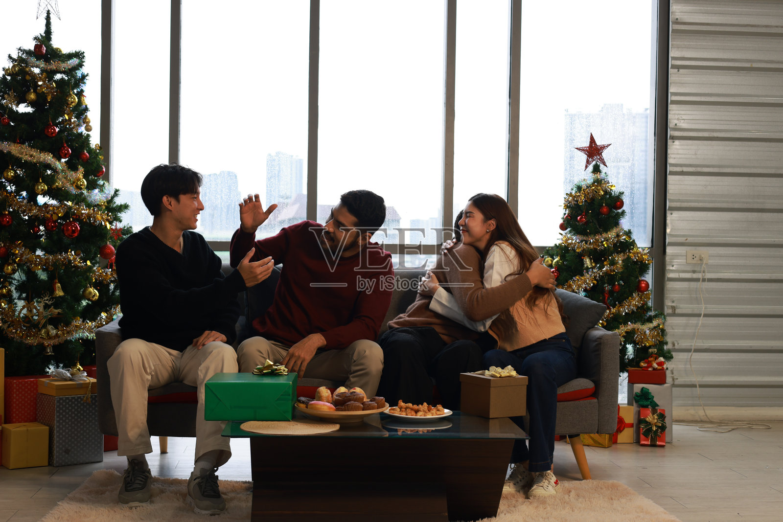 一群人在室内庆祝圣诞派对,和朋友、家人及同事们一起微笑交谈,享受节日的气氛。照片摄影图片