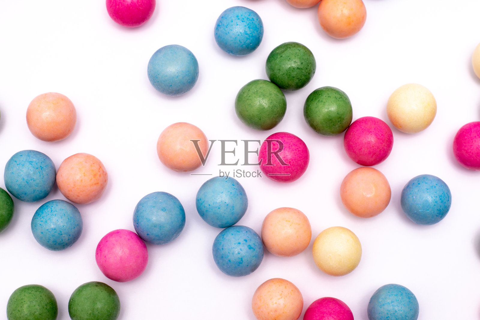 一堆五颜六色的糖果球散落在白色背景上照片摄影图片