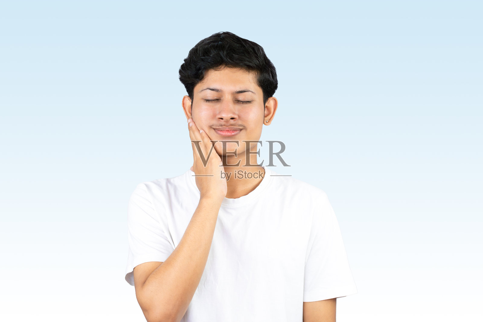 年轻男青少年模特,面部有痘痘,展示护肤美容产品,手持保湿霜姿势独特。照片摄影图片