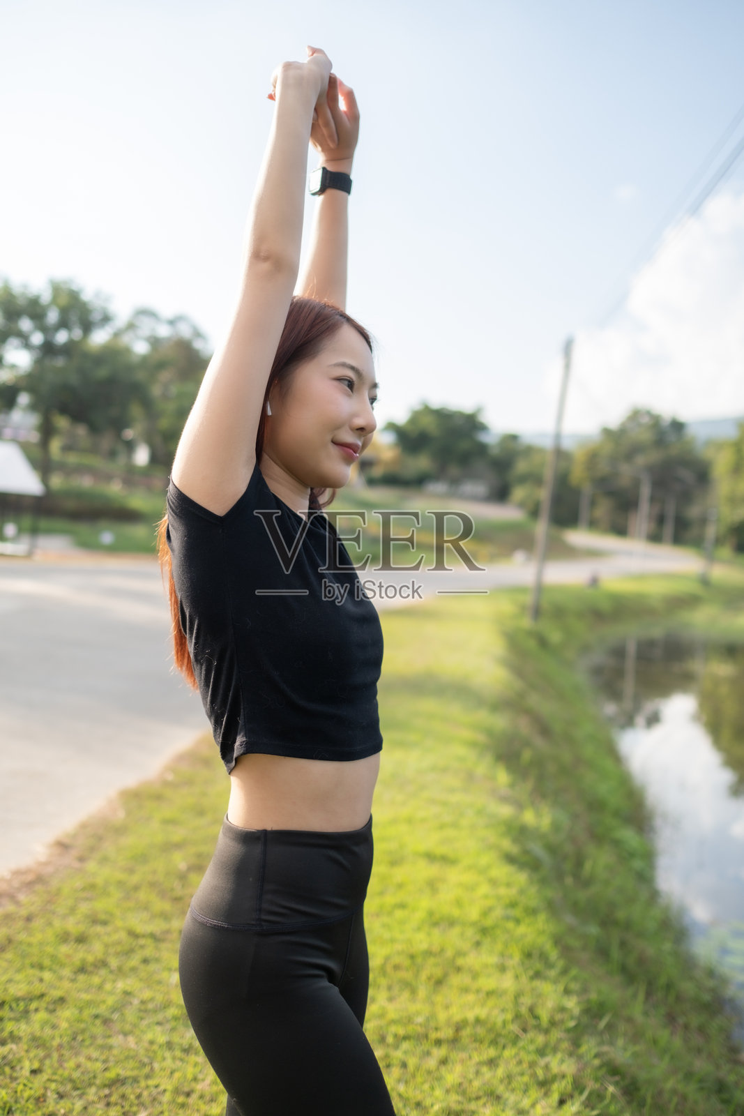 一位穿着黑色衬衫的女性正在伸展双臂。照片摄影图片