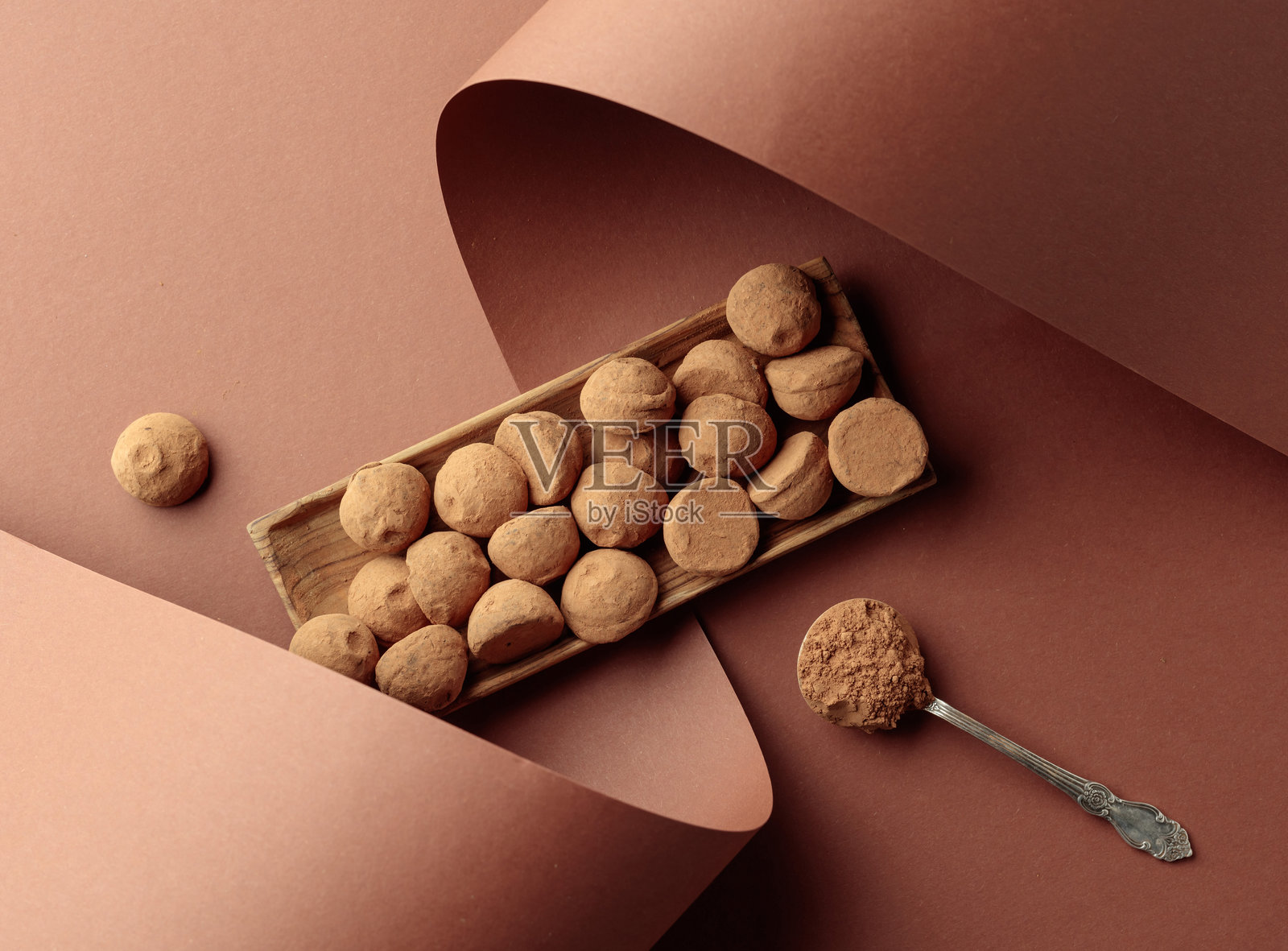 巧克力松露和撒有可可粉的勺子。照片摄影图片