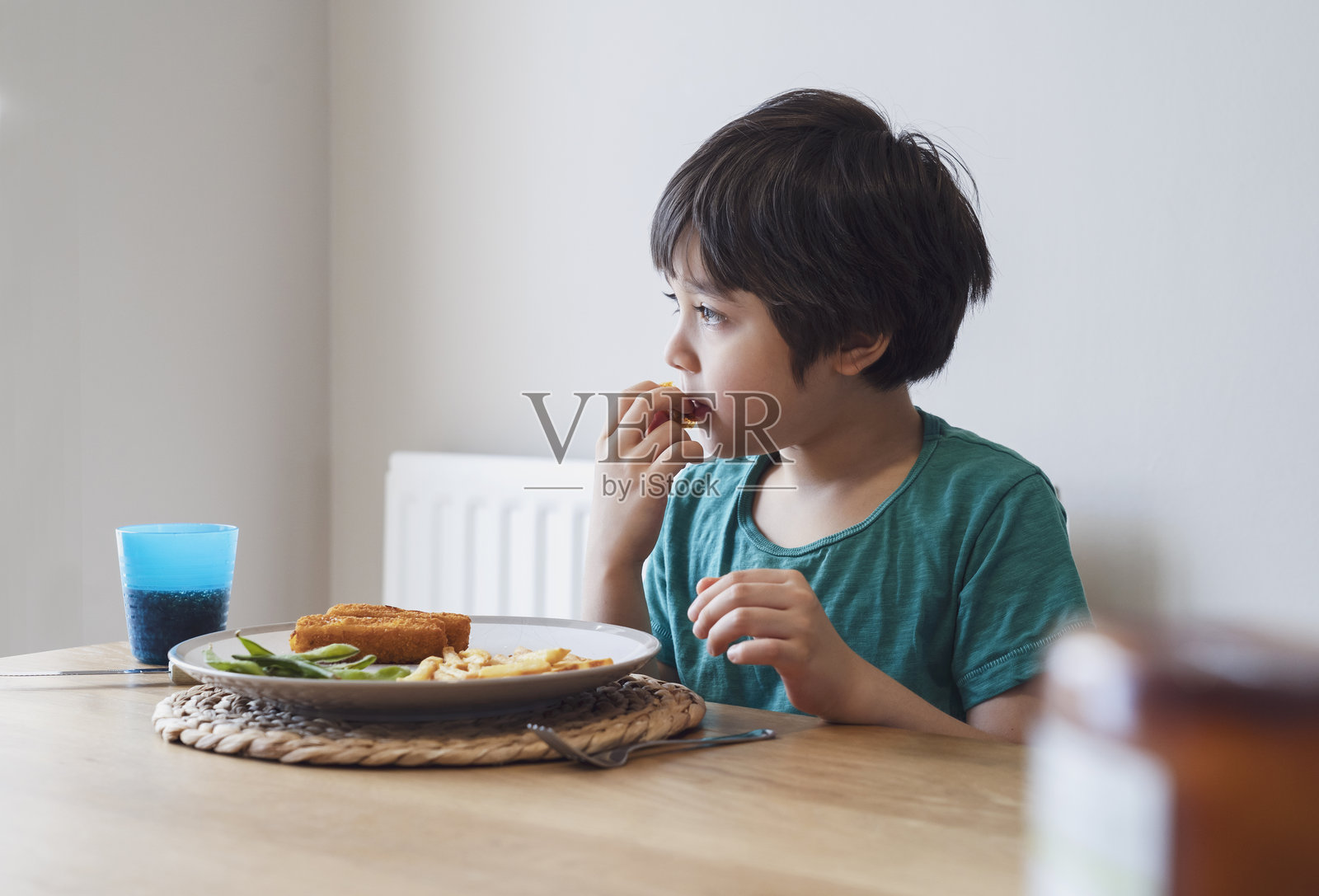 可爱男孩在家里坐着吃东西照片摄影图片