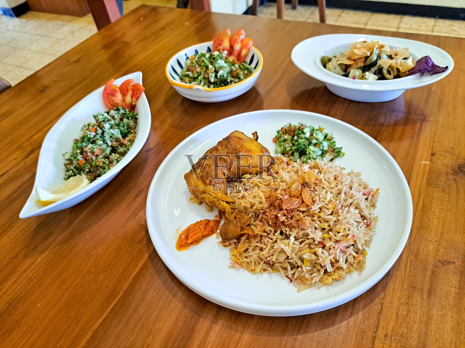 鸡肉曼迪饭,塔布勒沙拉,阿拉伯沙拉和法图什沙拉。中东美食菜单。照片摄影图片