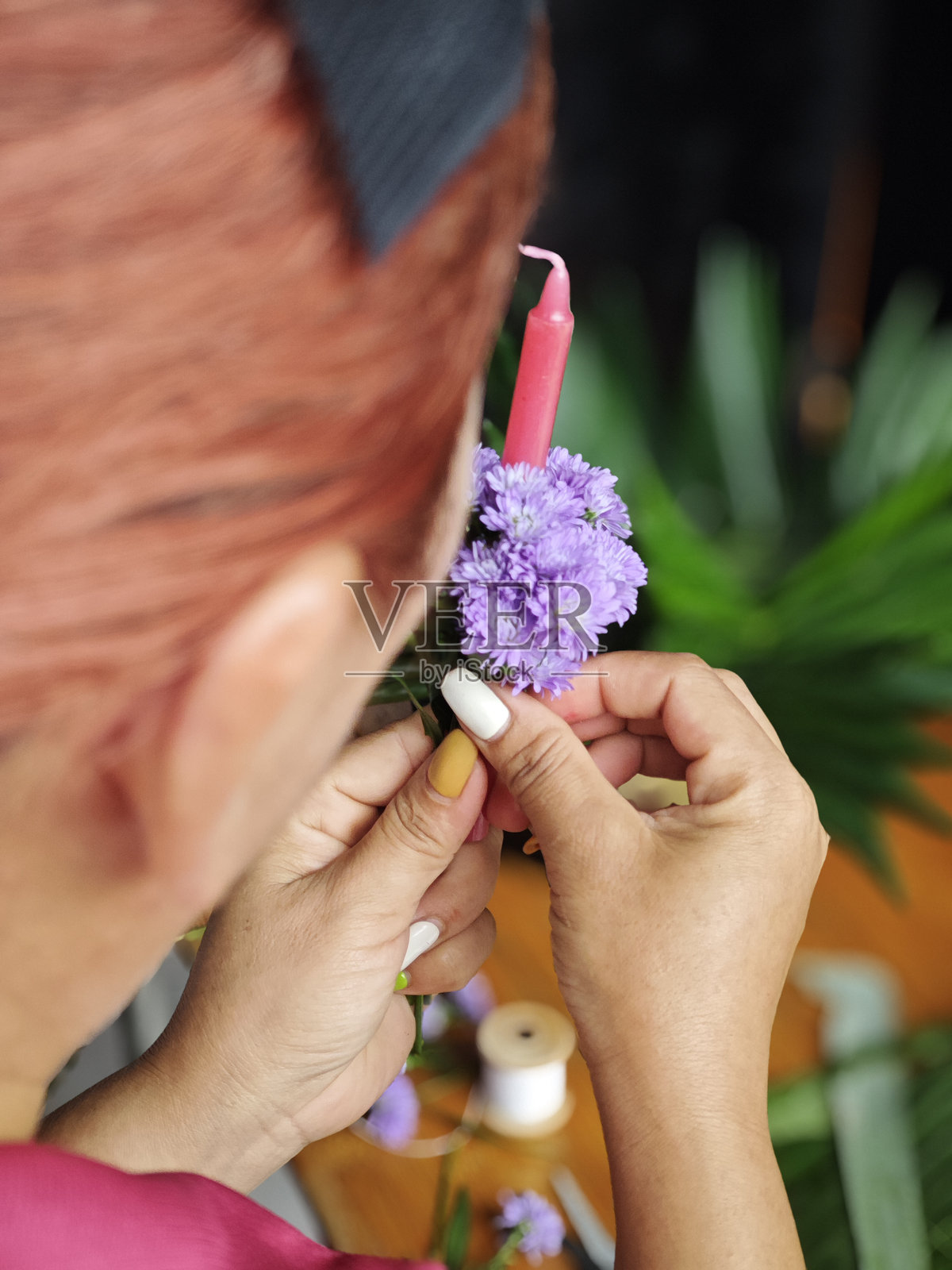 “幕后花絮:泰国传统水灯制作” 描述:抓拍女性在安静地制作水灯的背影,专注于花朵和叶子的排列。照片摄影图片