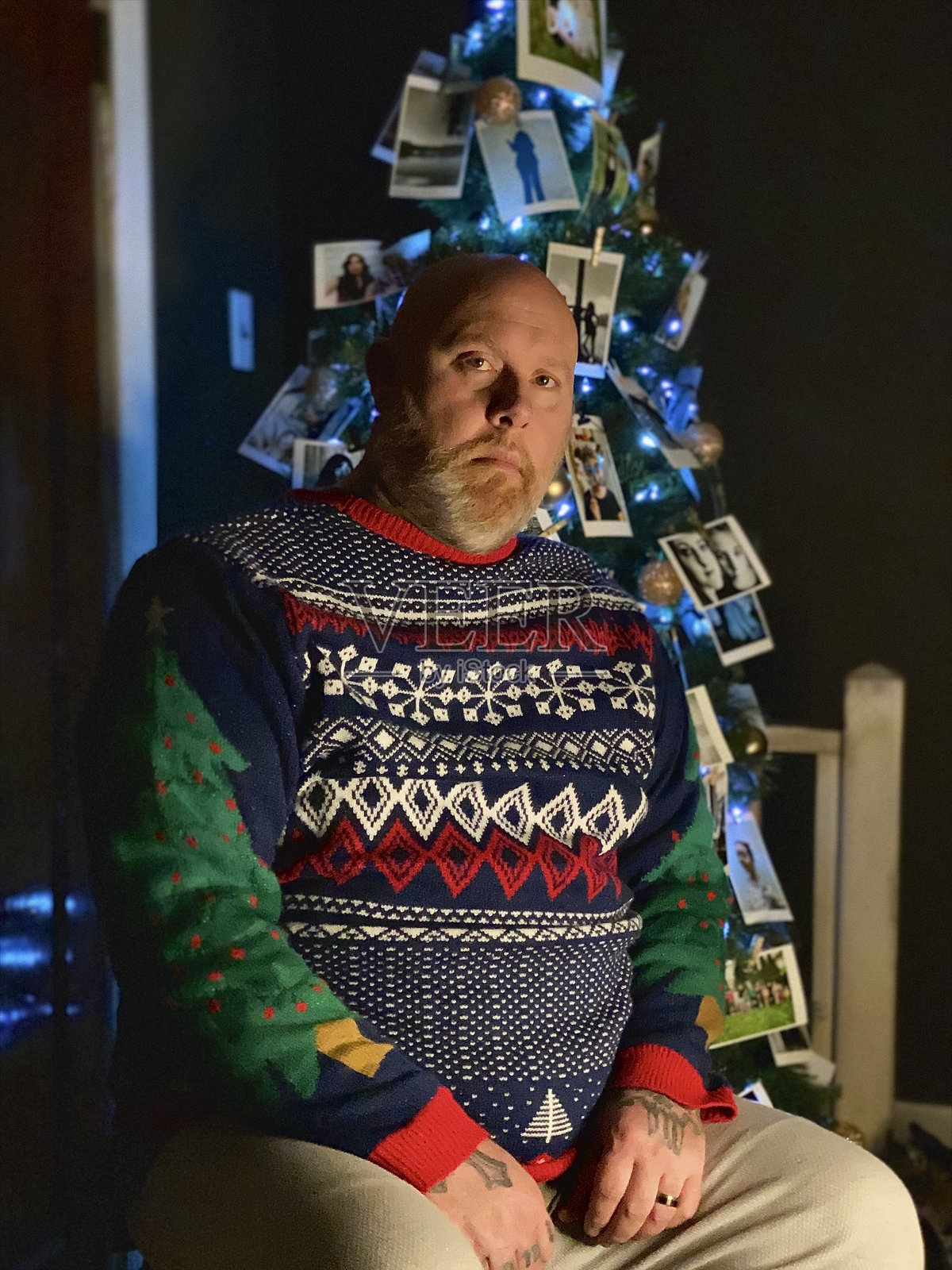 穿着毛衣的早发性阿尔茨海默病患者在圣诞树前。照片摄影图片