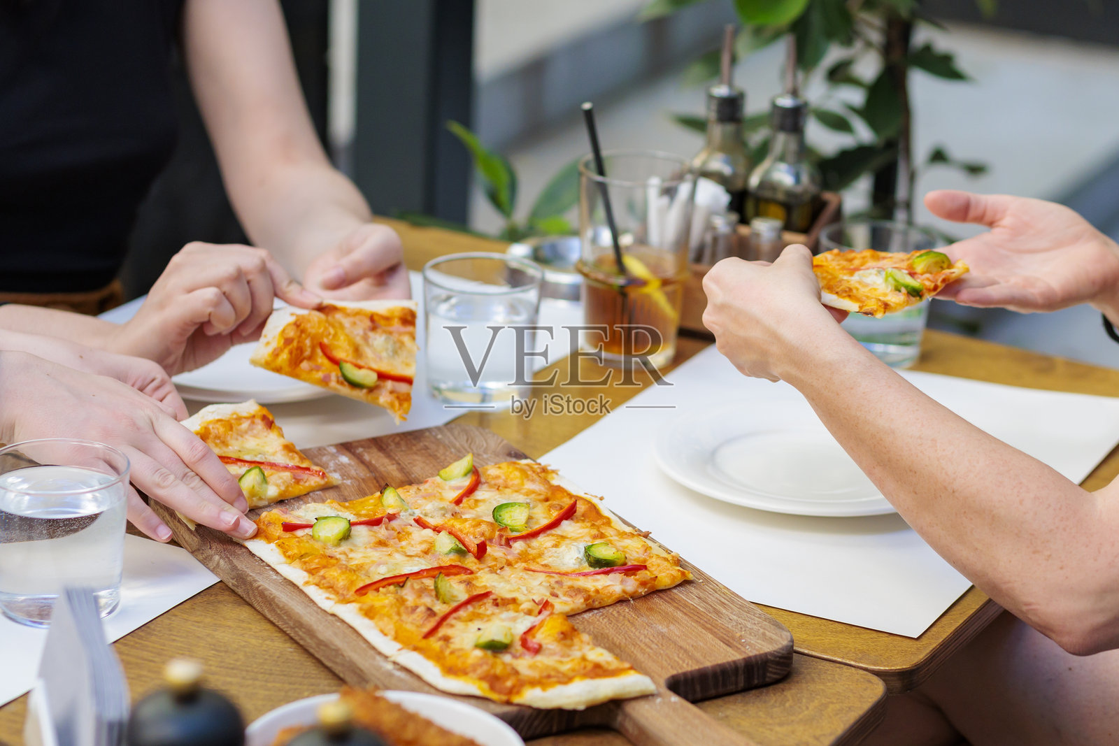 人们在吃扁平面饼风格的比萨饼照片摄影图片
