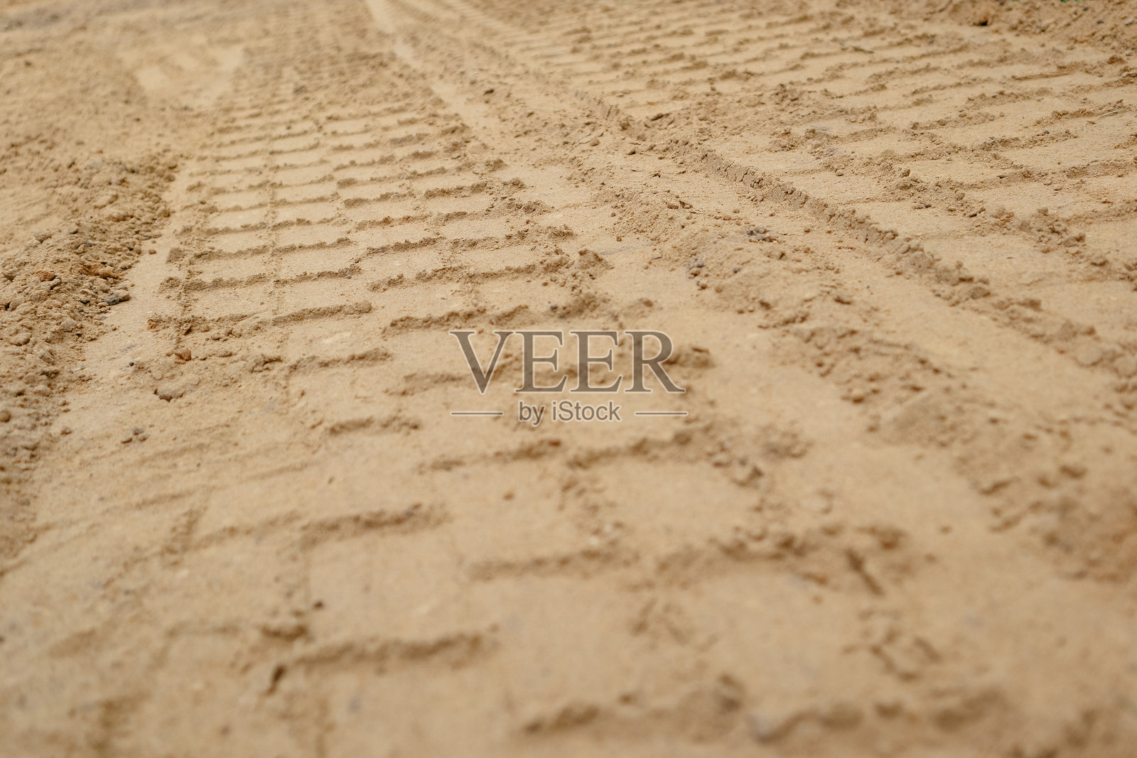 沙滩上的轮胎印记背景。沙滩上的轮胎轨迹和脚印。机器印记。照片摄影图片