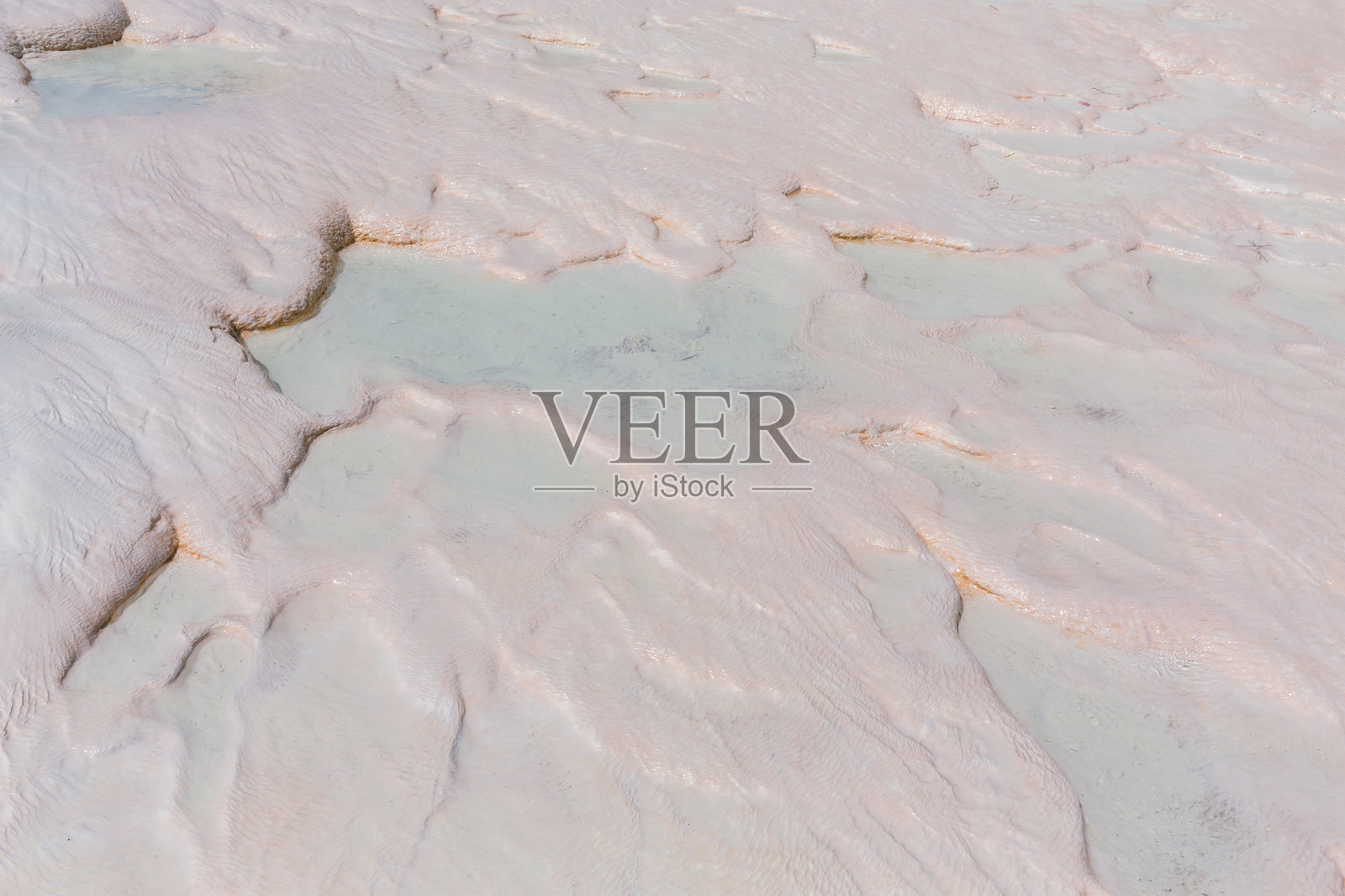 帕穆卡莱温泉的特写,展示了光滑的梯田状地貌和浅蓝色水池。帕穆卡莱,德尼兹利,土耳其。照片摄影图片