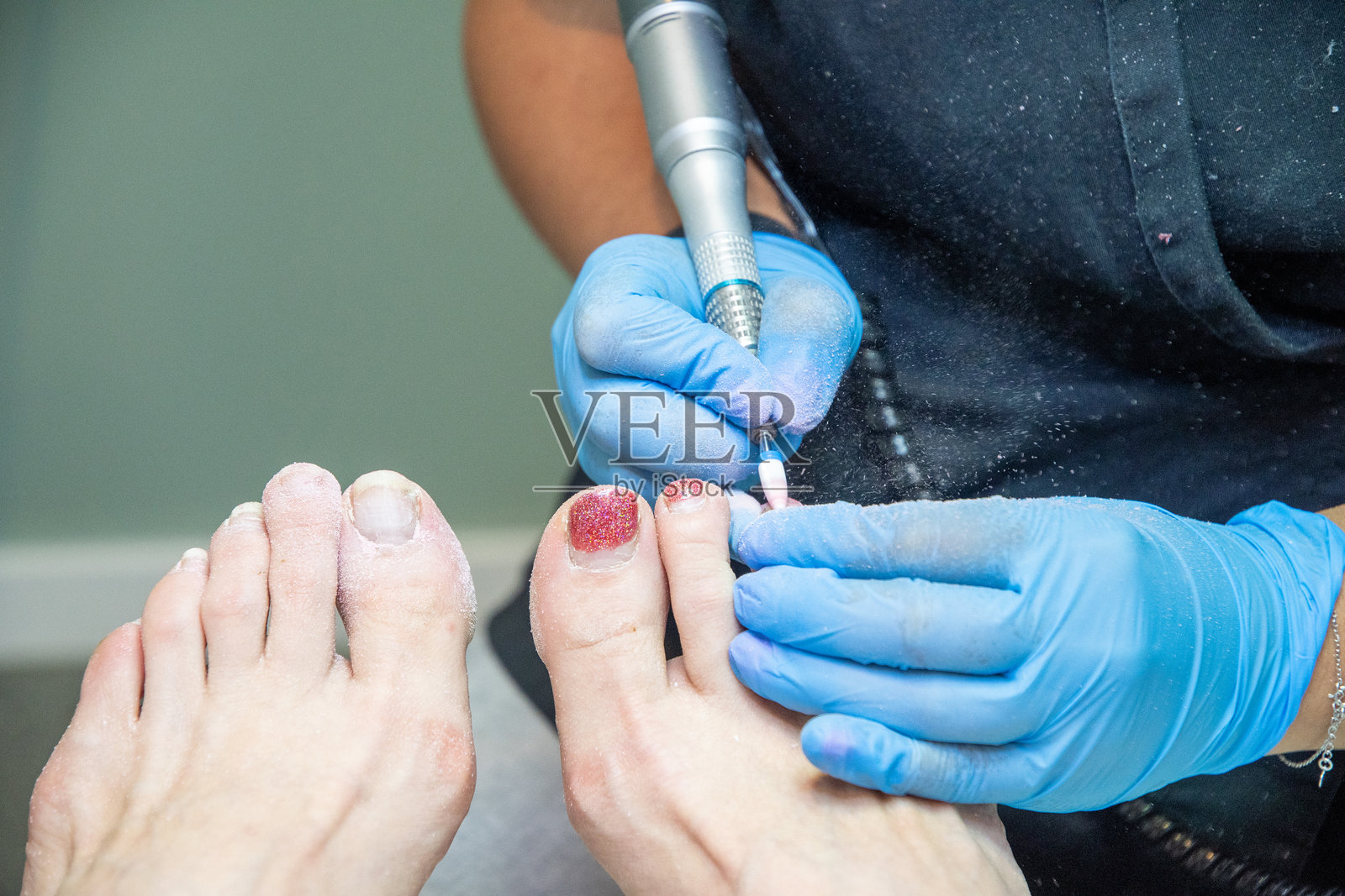 美容院的技师为客户进行硬件足部护理,柔焦效果照片摄影图片