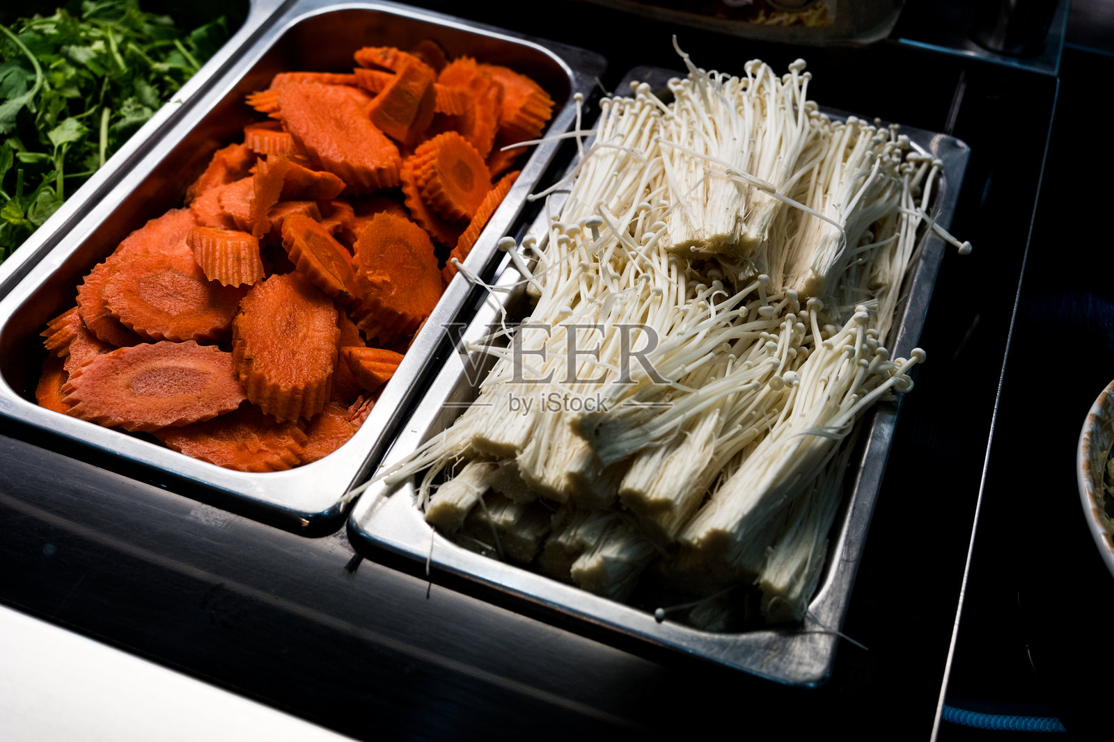 不锈钢托盘中的生胡萝卜片和生金针菇照片摄影图片