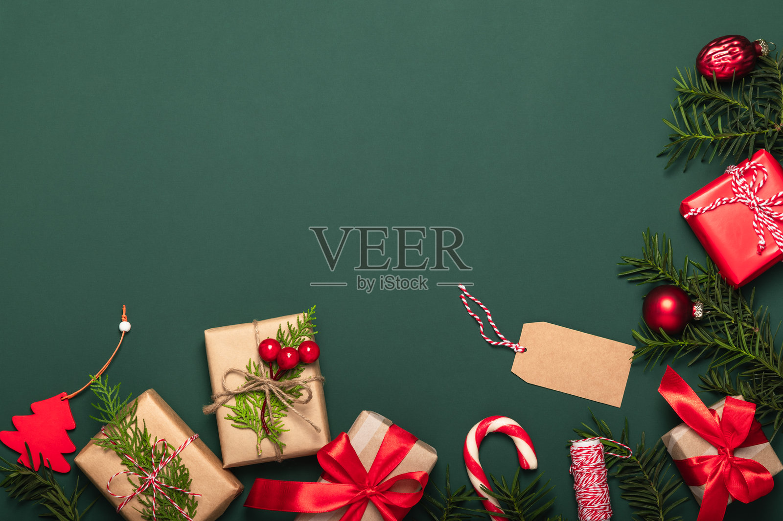 节礼日概念。松树枝和纸质礼品盒,搭配西洋杉枝、红色圣诞糖果手杖和手工标签,围绕着针叶树枝的框架。照片摄影图片