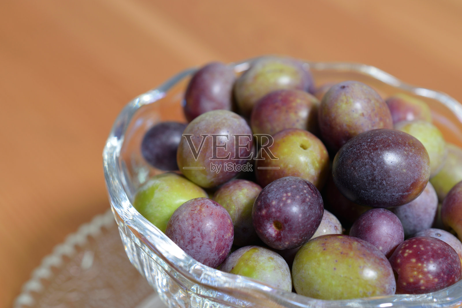 美丽丰盈的橄榄果在室内的容器中拍摄。照片摄影图片