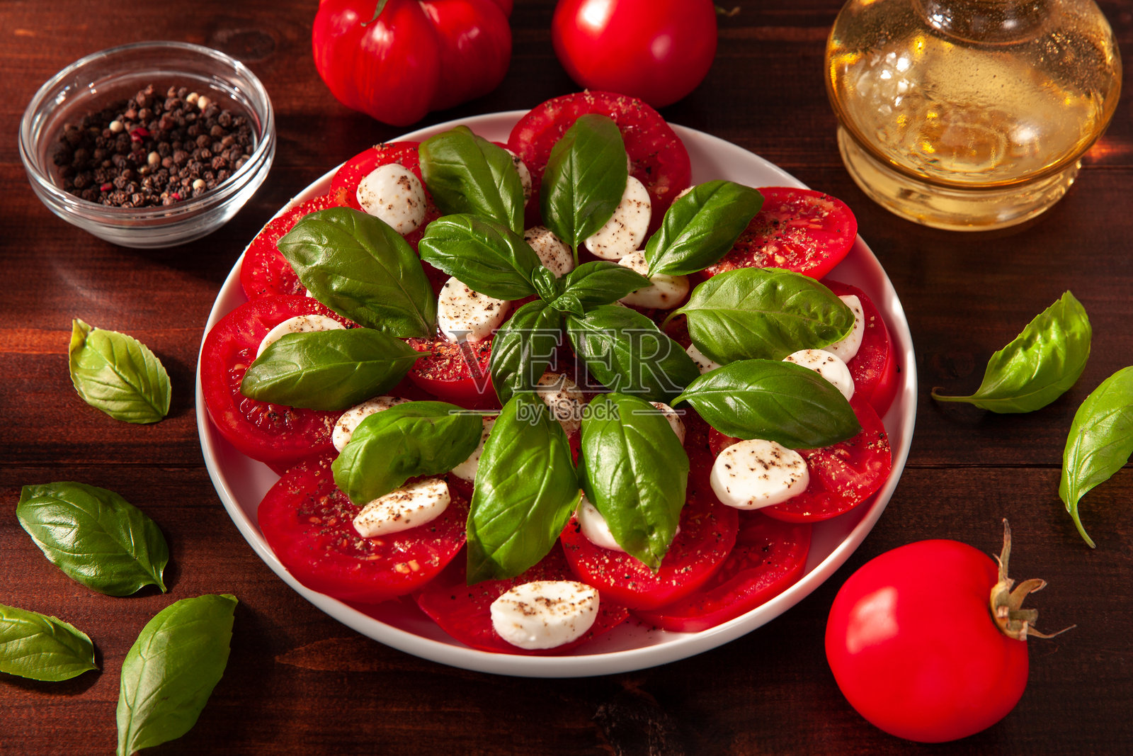 新鲜的卡普雷塞沙拉,配有切片番茄、马苏里拉奶酪和罗勒照片摄影图片