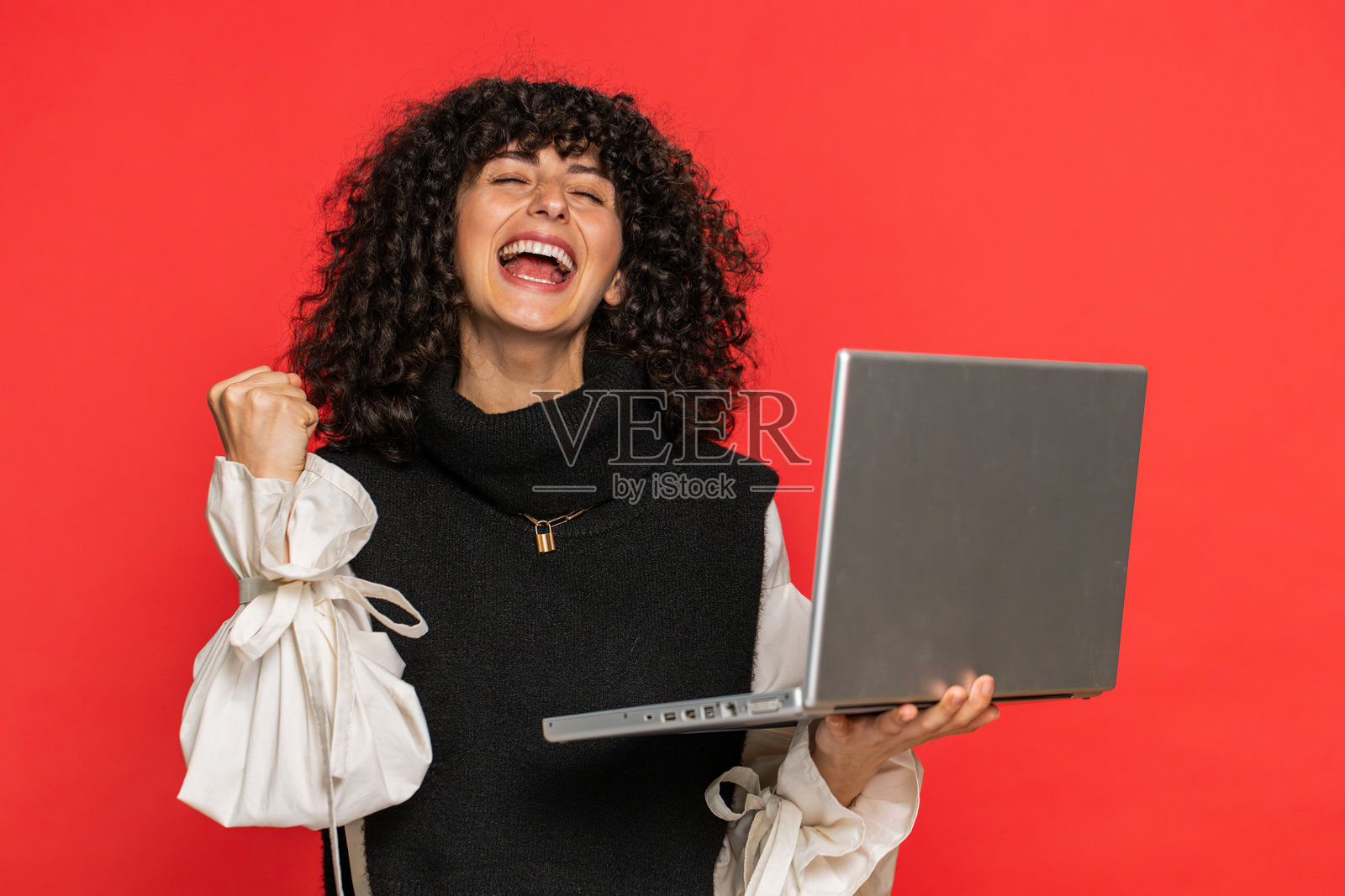 兴奋快乐的年轻女性在笔记本电脑上工作,庆祝在线彩票游戏的成功胜利照片摄影图片