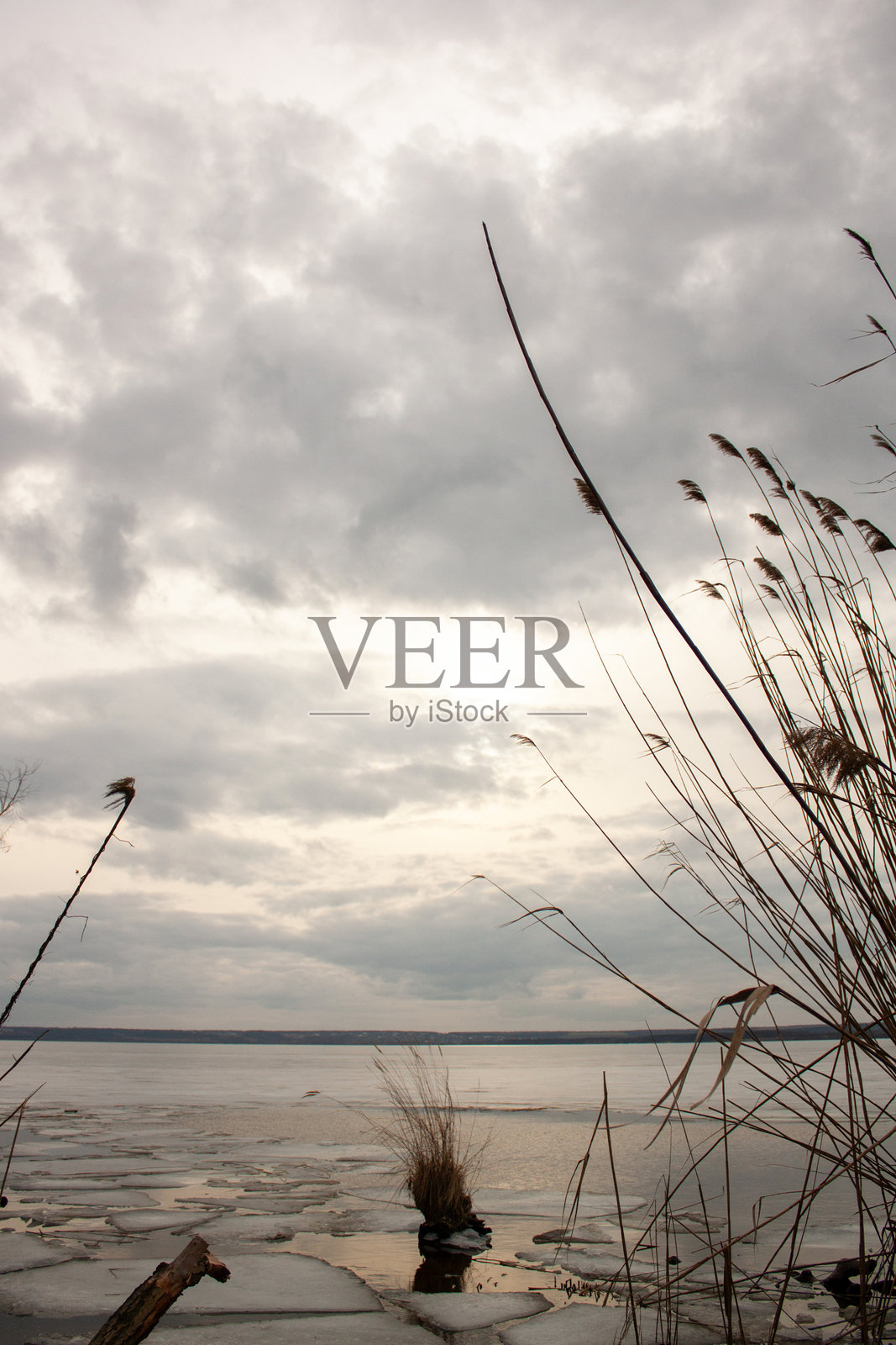 一个湖泊,湖面结冰,背景是多云的天空照片摄影图片