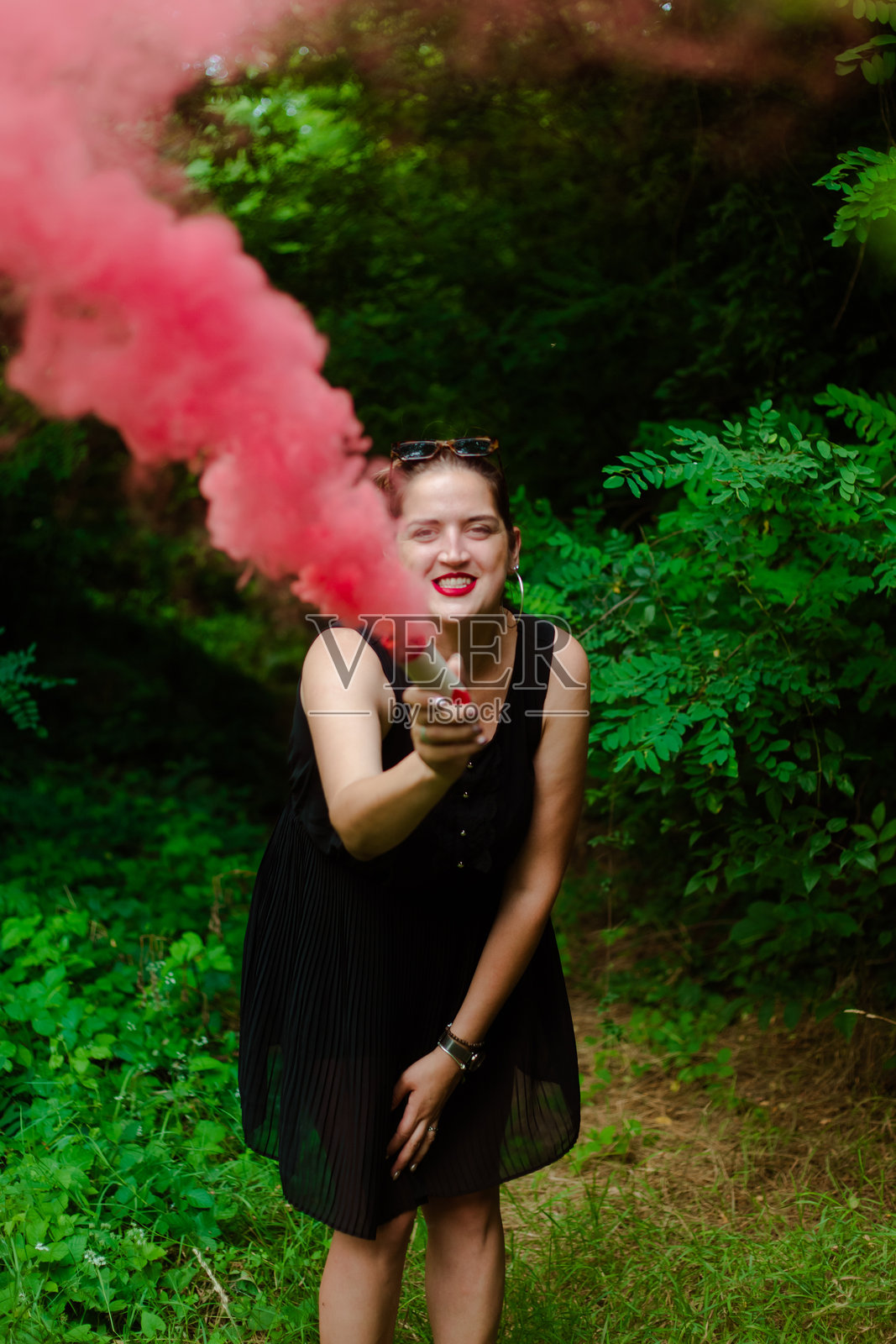 年轻女性与粉色烟雾玩乐的照片照片摄影图片