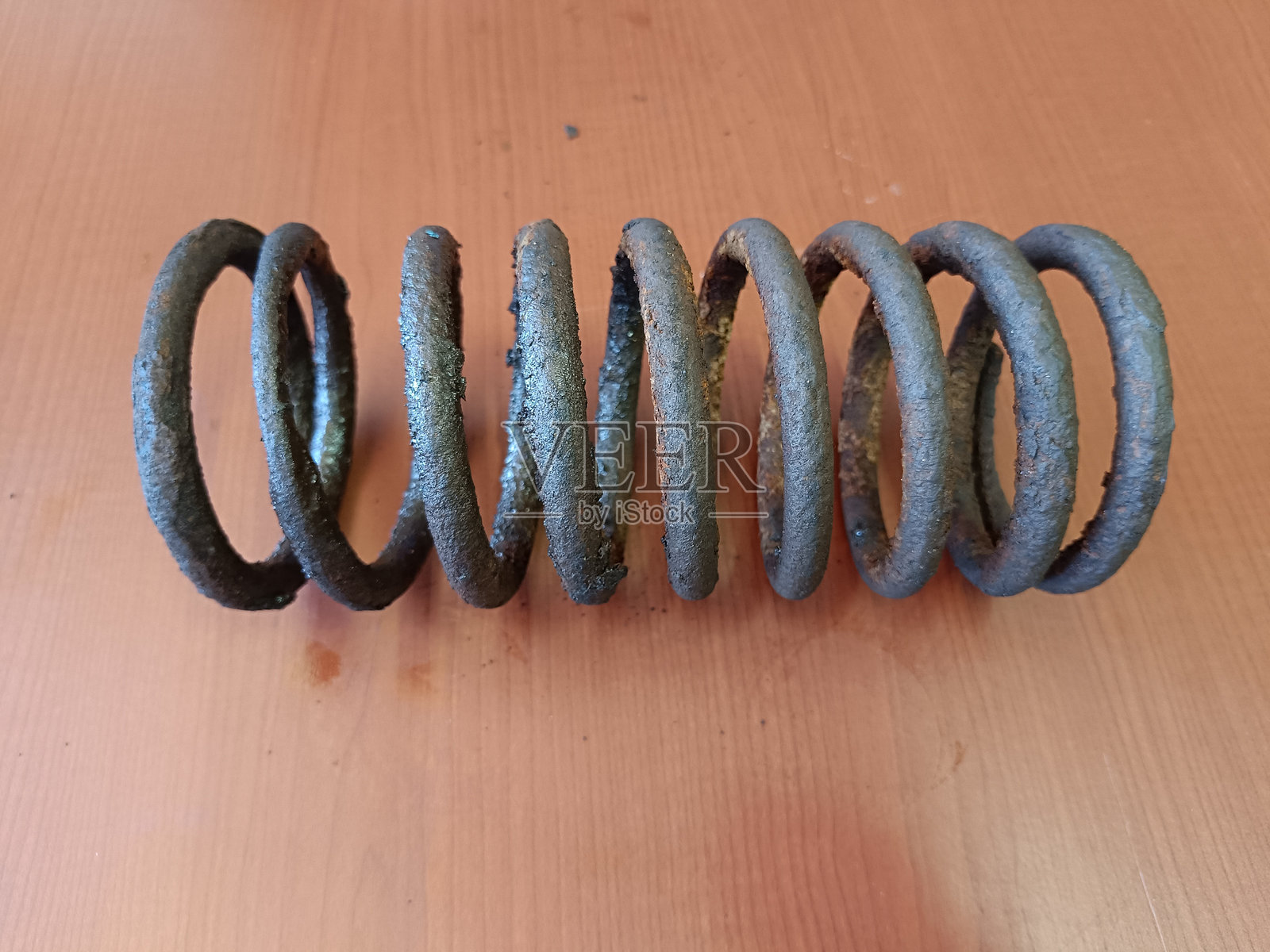 一个生锈的金属弹簧,表面可见腐蚀痕迹照片摄影图片