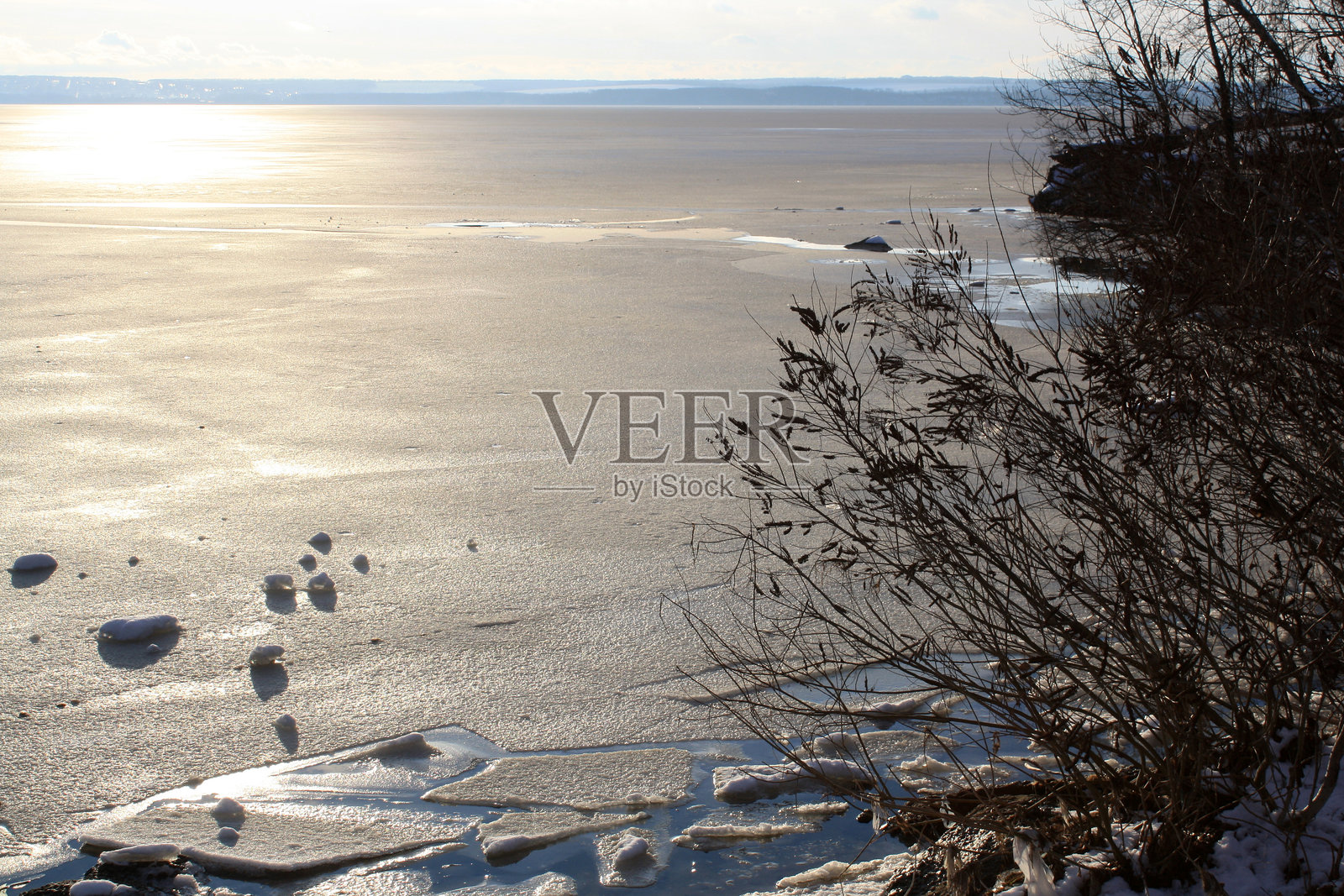 湖边的日落,背景有几棵树。照片摄影图片