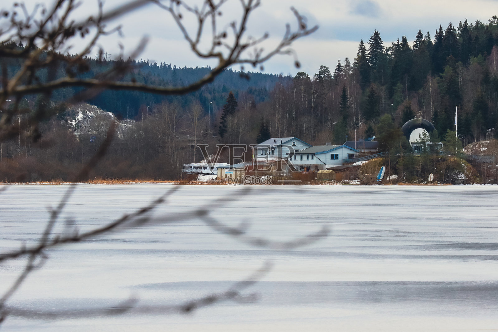 挪威宁静的冬季风景,冰冻的湖泊和树木间的小屋。照片摄影图片