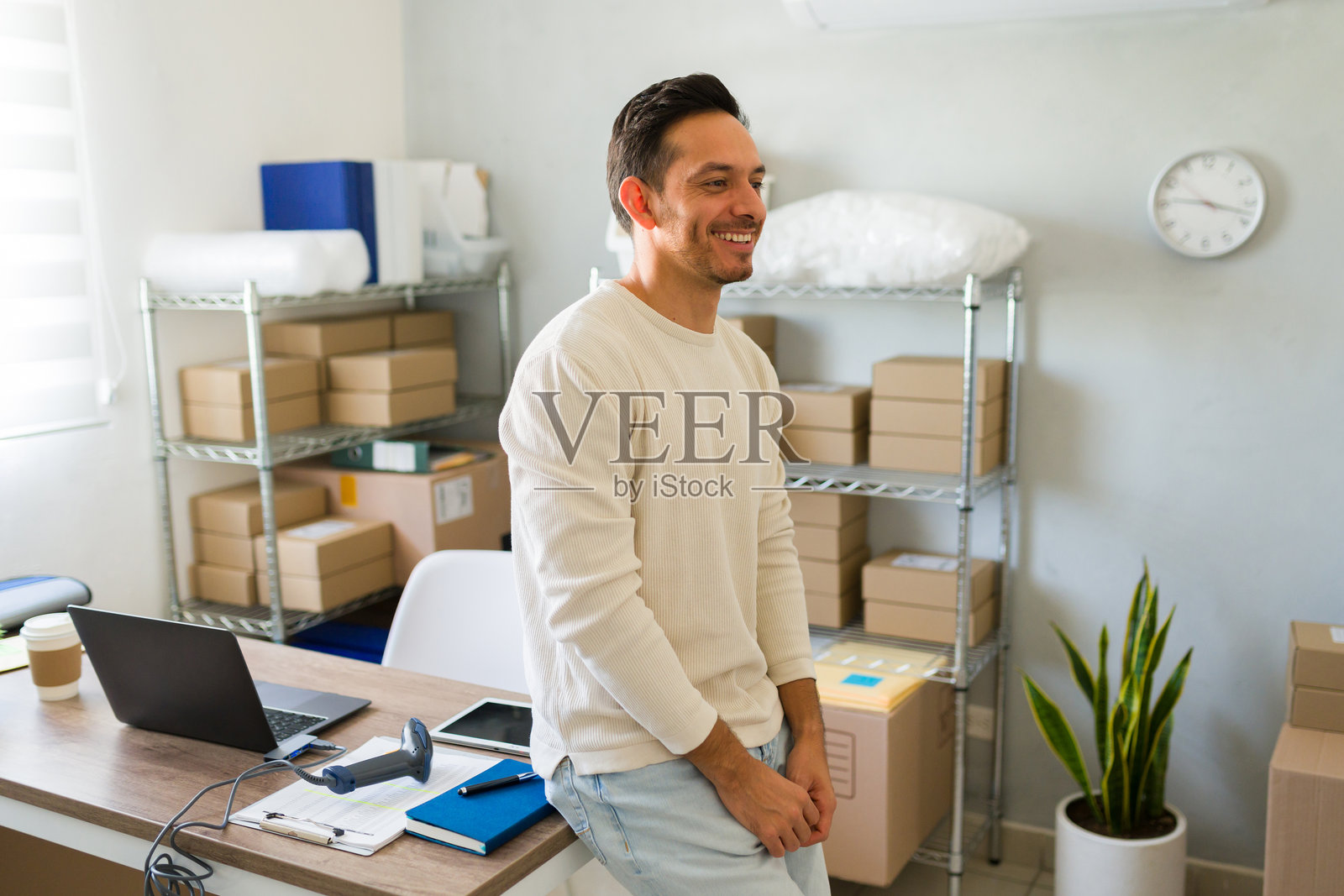 自豪的拉丁裔企业家在家中成功经营电子商务业务,愉快地在办公室管理包裹照片摄影图片
