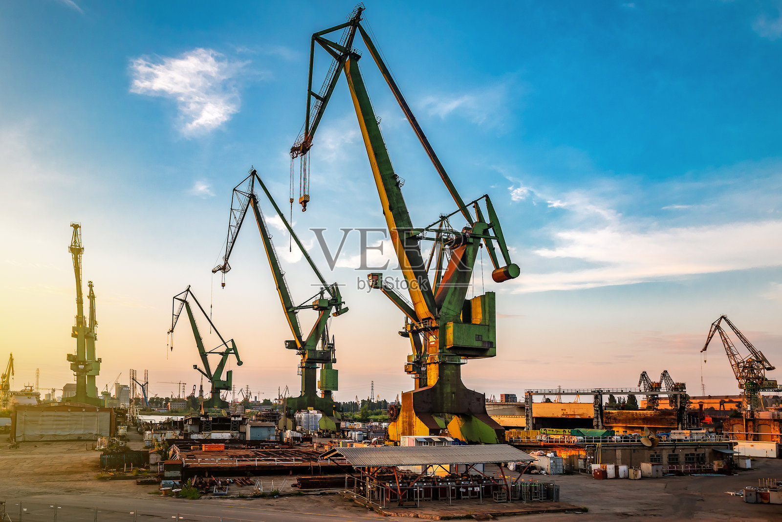 日落时分的工业港口起重机工作场景照片摄影图片