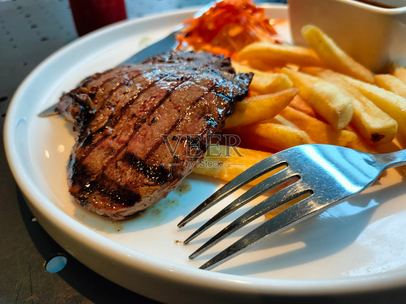 烤牛排特写,配薯条和烧烤酱照片摄影图片