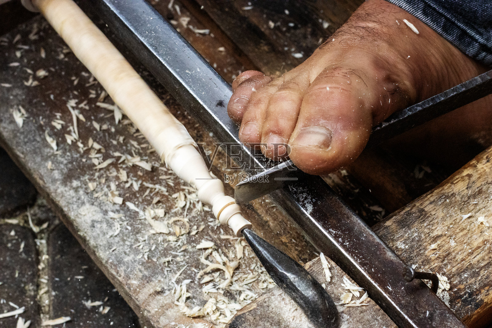 脚踩着凿子,在摩洛哥马拉喀什的老城区市场上用手动车床旋转木材照片摄影图片
